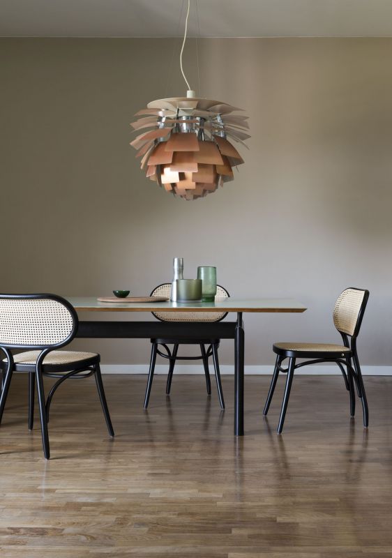 Esszimmer mit modernem Esstisch, Stühlen mit Rattan und Designer-Hängelampe aus Holz.