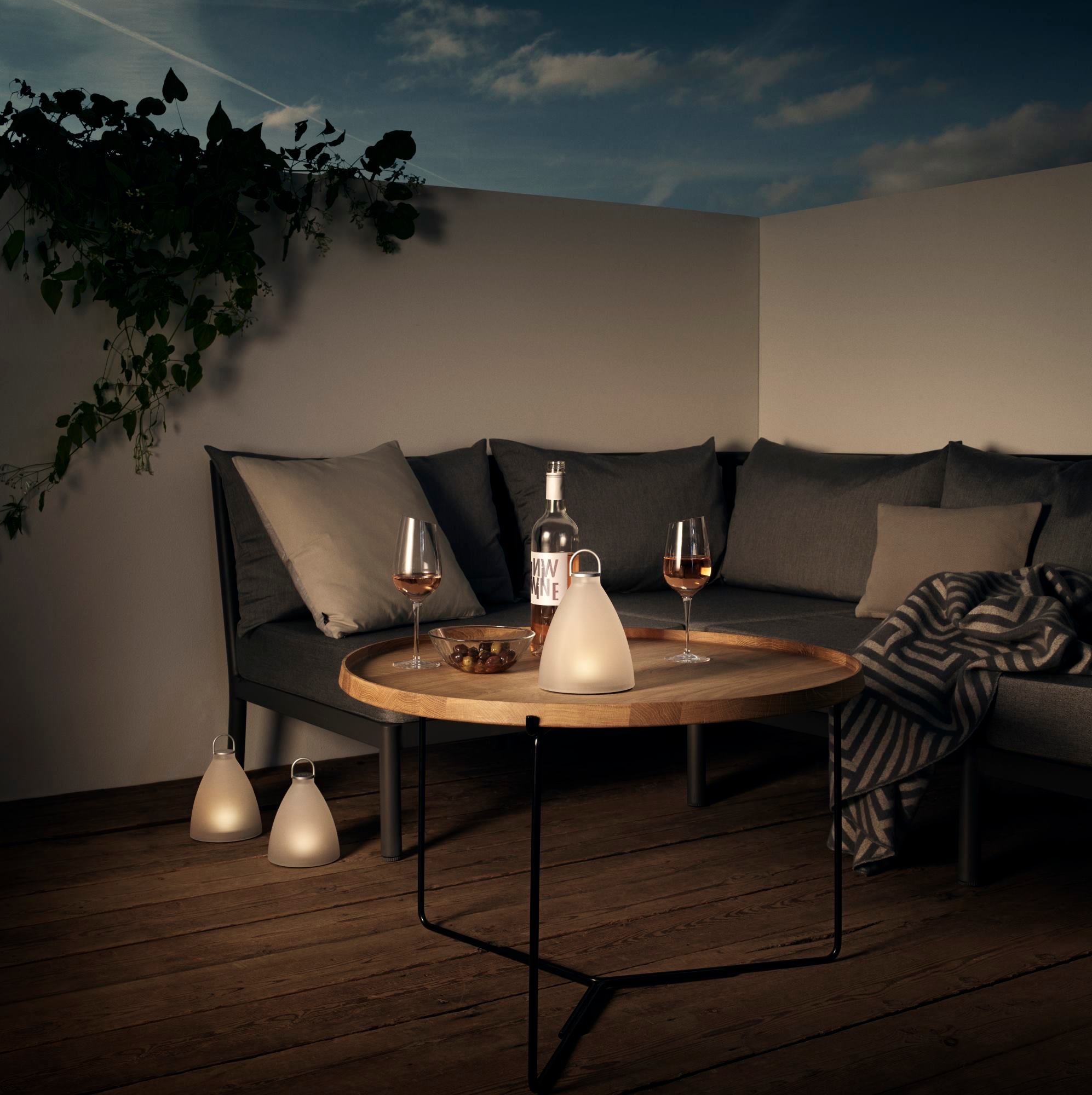 Sun Light Bell Solarleuchte von Eva Solo auf Tisch mit Wein und Gläsern.