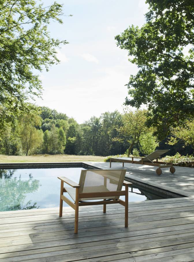 Pelagus Sessel von Skagerak by Fritz Hansen neben Pool auf Holzdeck mit Liege.