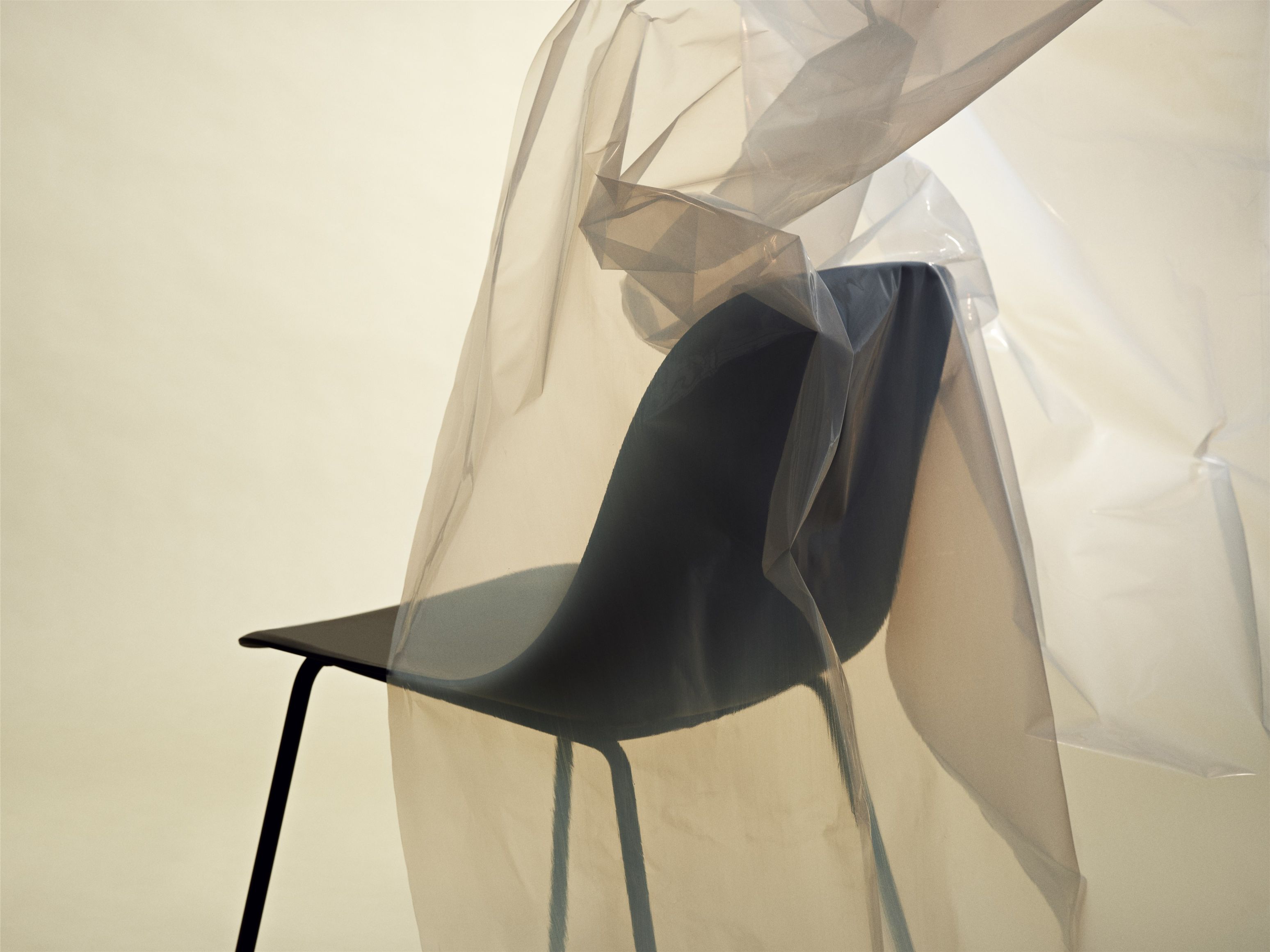 Fiber Side Chair von Muuto, minimalistischer Stuhl mit schwarzem Gestell und Kunststoffschale, teilweise verdeckt.