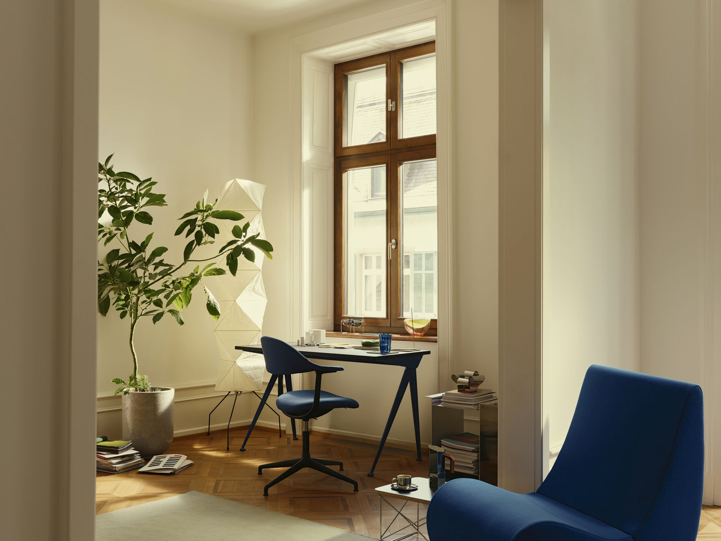 Mynt Bürodrehstuhl von Vitra mit blauer Sitzschale und Rückenlehne in einem hellen, modernen Arbeitszimmer.