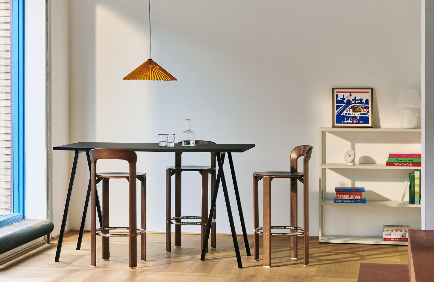 Drei Hay Rey Barhocker H97cm aus Holz an einem hohen, schwarzen Esstisch in modernem Ambiente.