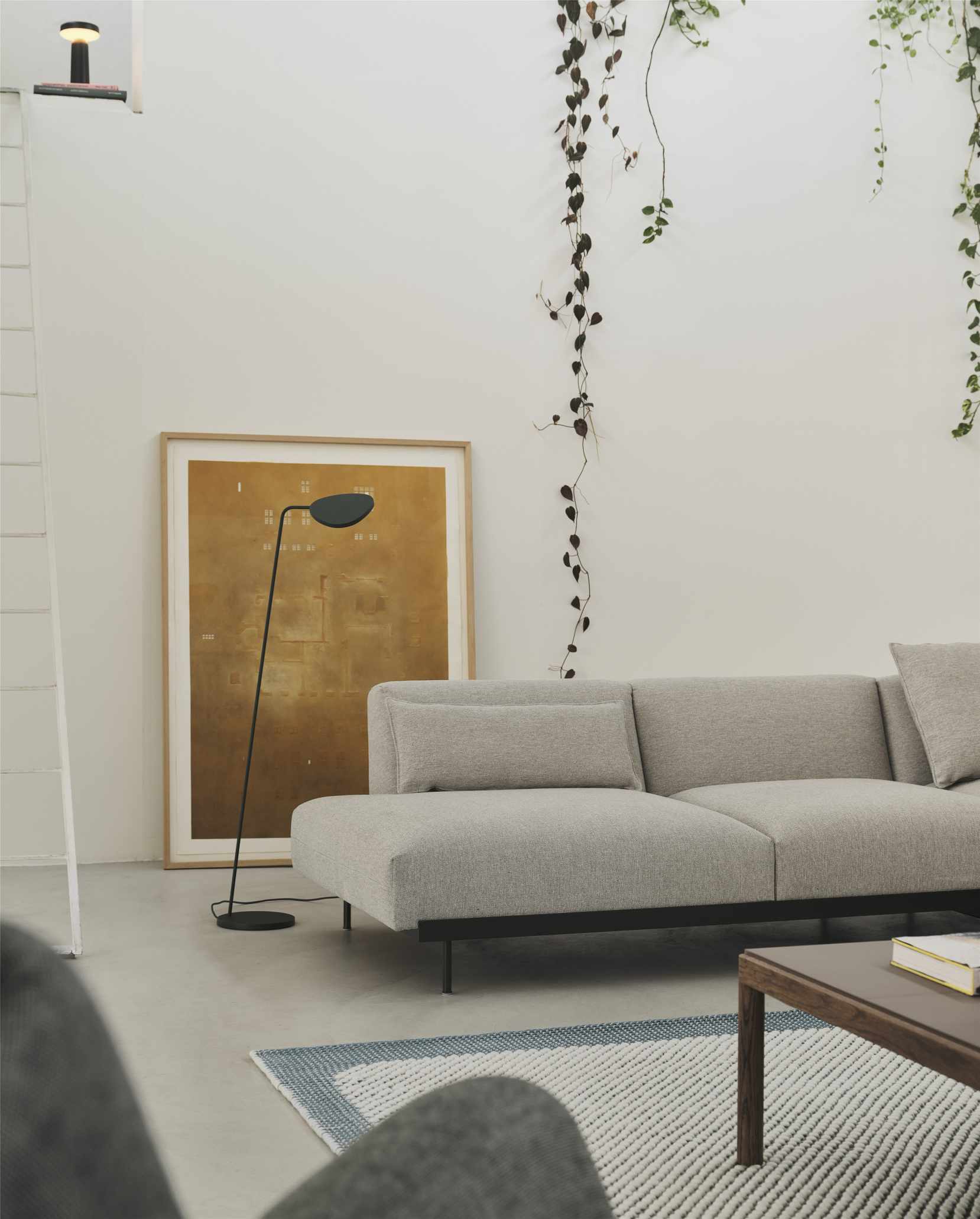 Heller Wohnraum mit Couch, Stehlampe und Muuto Couchtisch aus Holz.
