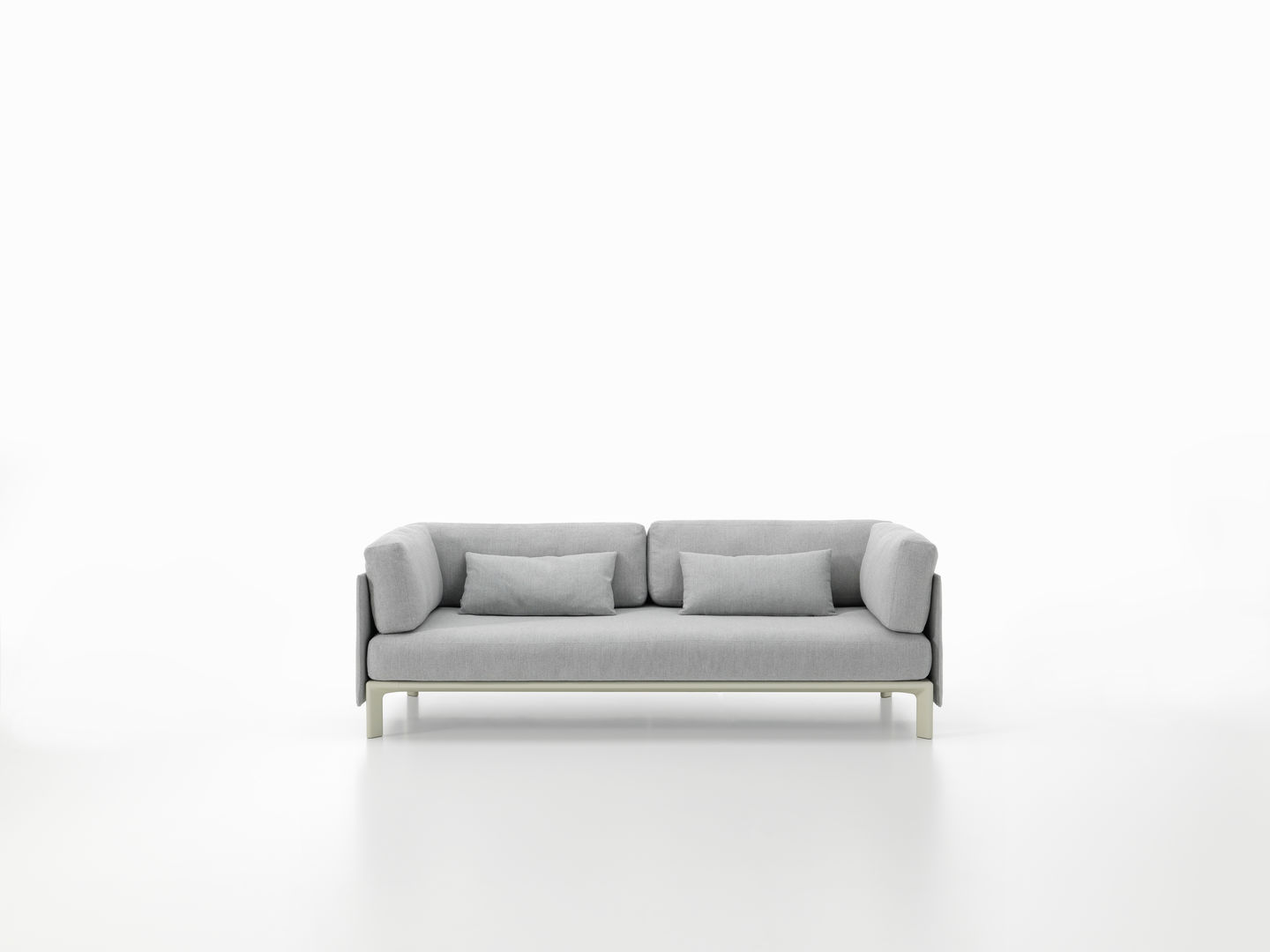 Graues Anagram Rückenkissen/Seitenkissen 110 cm von Vitra auf einem Sofa vor einem weißen Hintergrund.