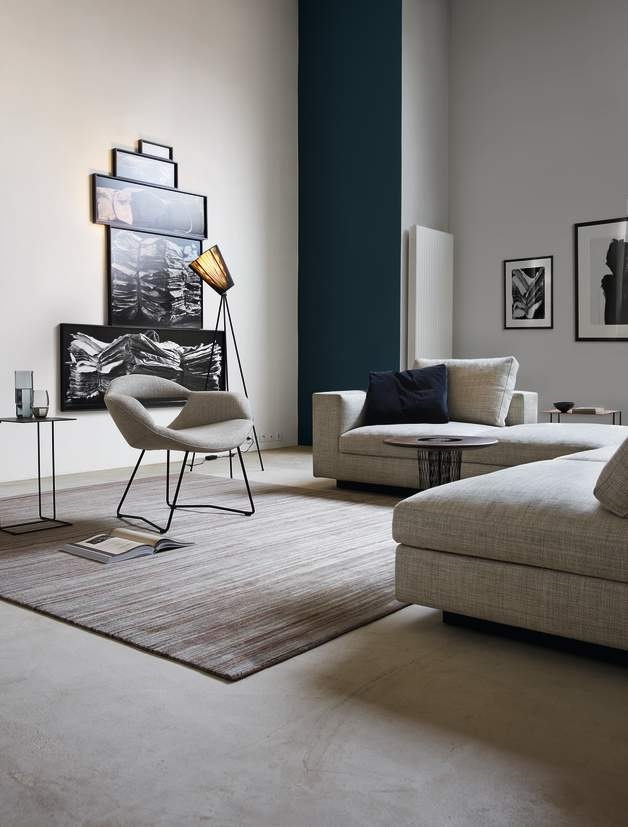 Moderner Wohnraum mit Walter Knoll Beistelltisch, grauem Sofa, Sessel und minimalistischer Dekoration.