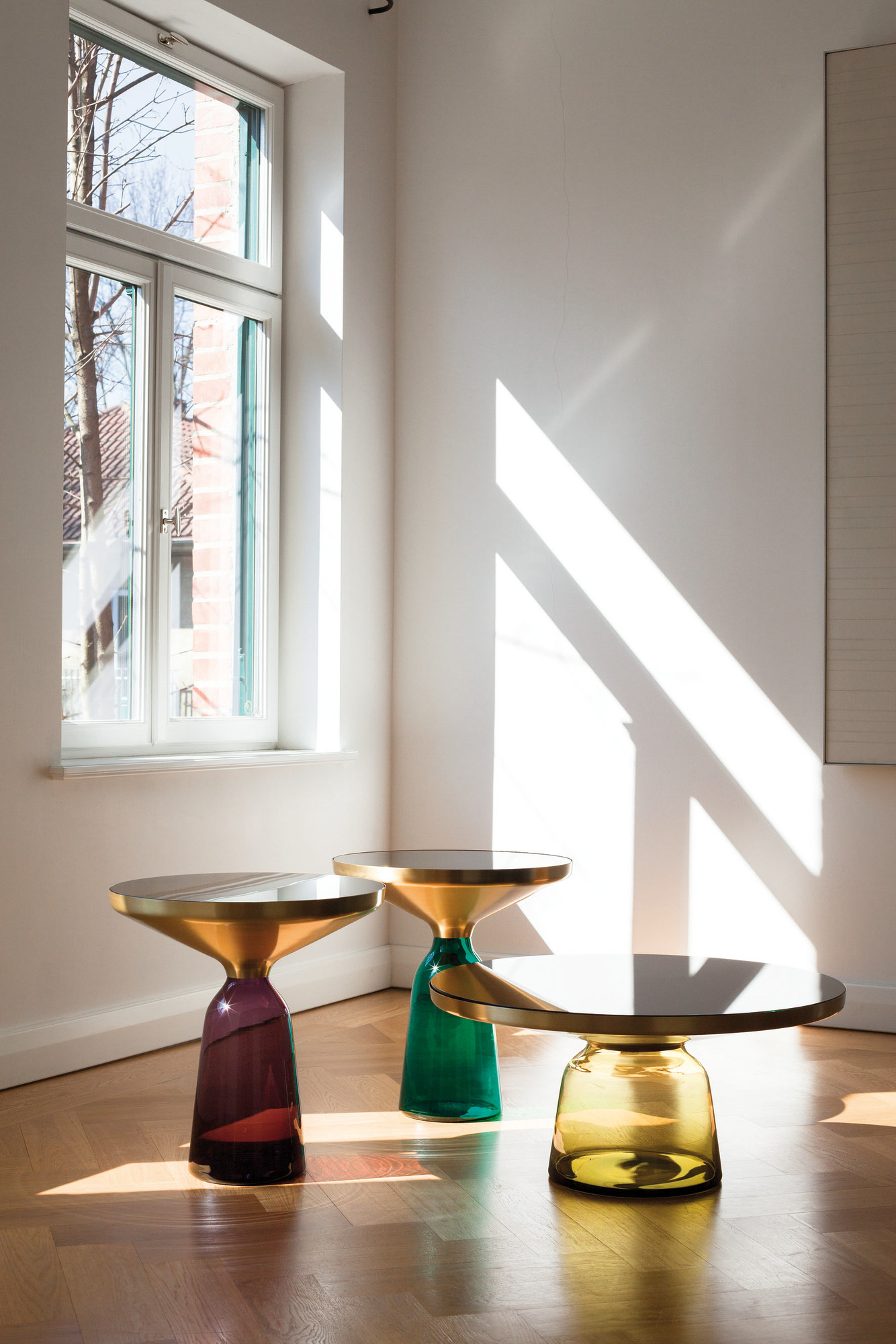 Drei ClassiCon Bell Side Tables mit Marmor Tischplatte in Gelb, Grün und Violett im sonnigen Raum.