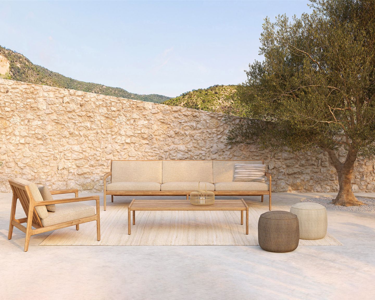 Outdoor-Lounge-Set aus Holz mit Sofa, Sessel, Tisch und Poufs auf einem Teppich im Garten.