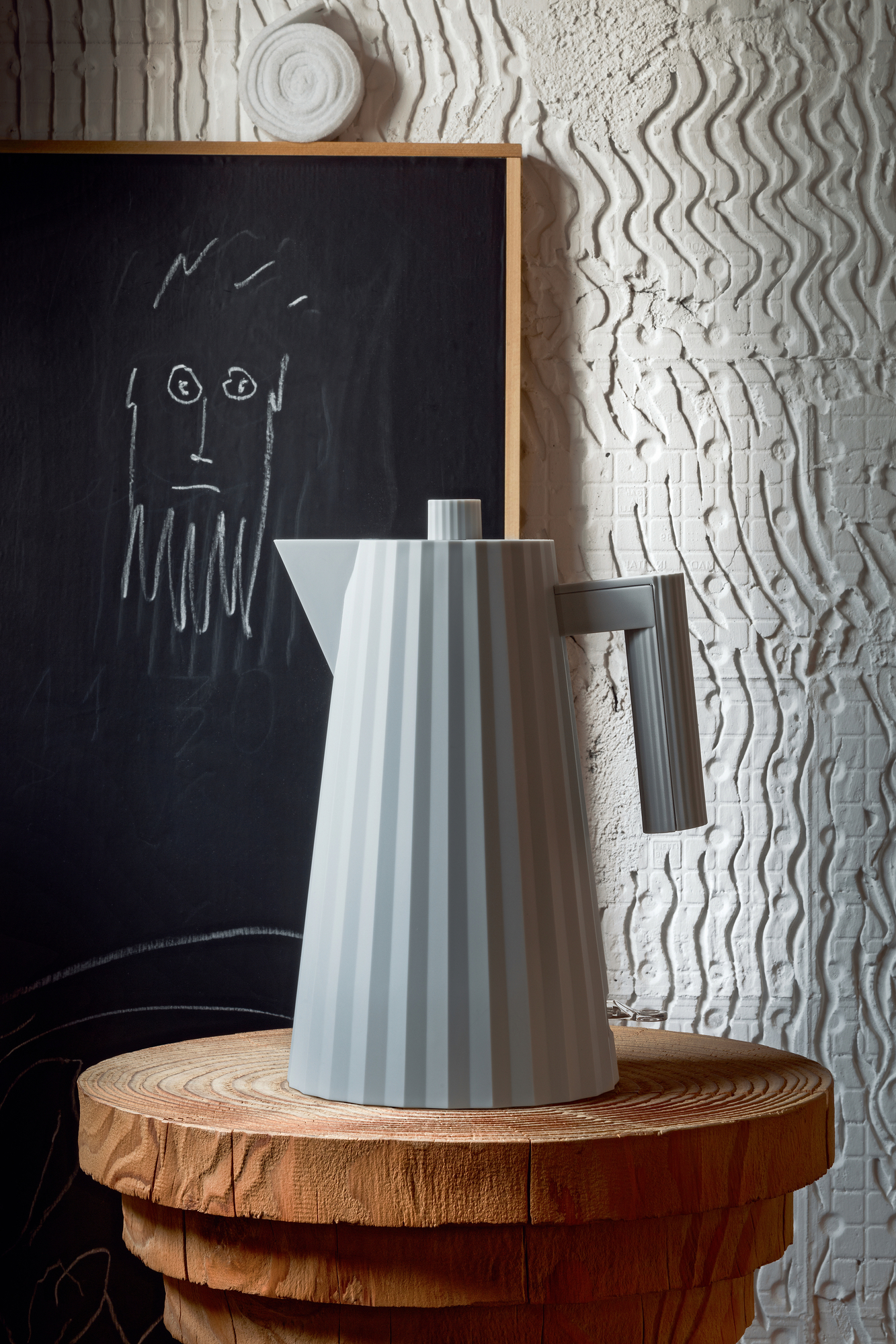 Grauer Alessi Plissé Wasserkocher MDL06 auf einem Holztisch, modernes Küchendesign.