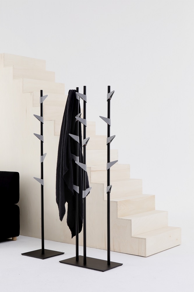 Cascando Standgarderobe aus Bambus mit schwarzem Mantel vor einer hellen Treppe im minimalistischen Design.