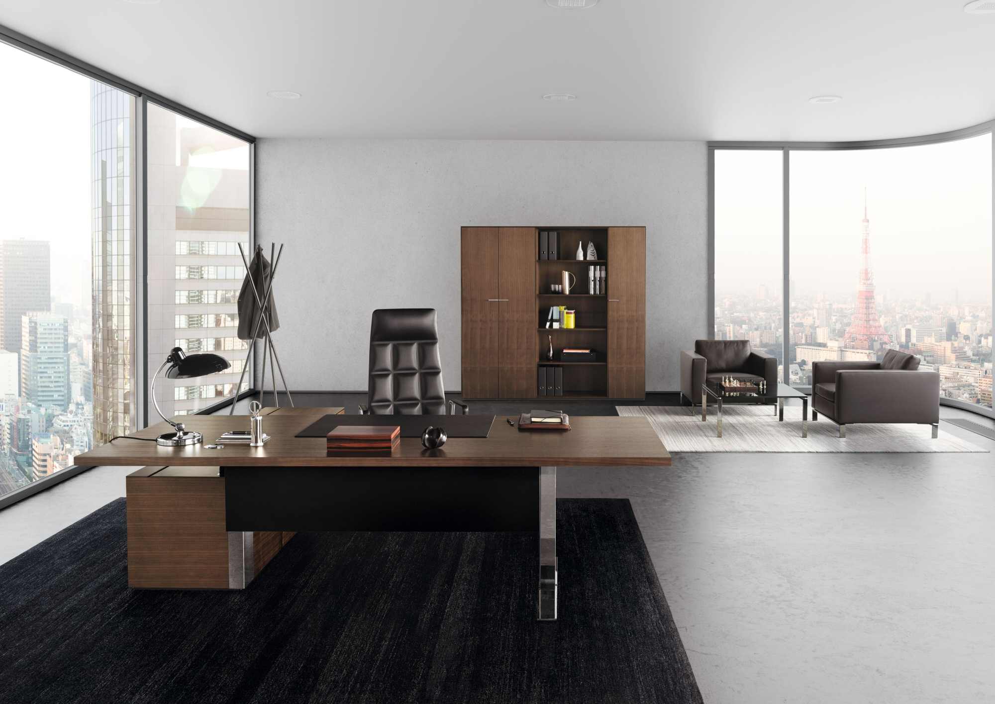 Büro mit schwarzem 503 Foster Sessel von Walter Knoll, Schreibtisch und Ledersesseln vor Skyline.