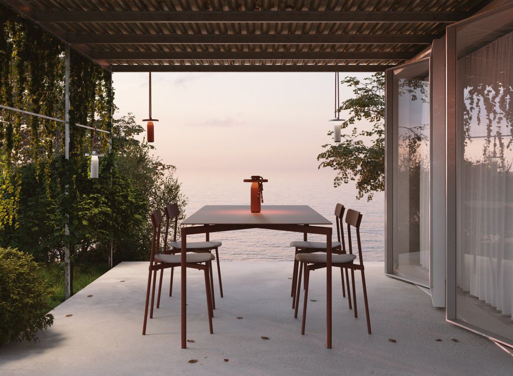 Fromme Esstisch rechteckig von Petite Friture, weiß, mit Stühlen auf einer Terrasse am Meer.