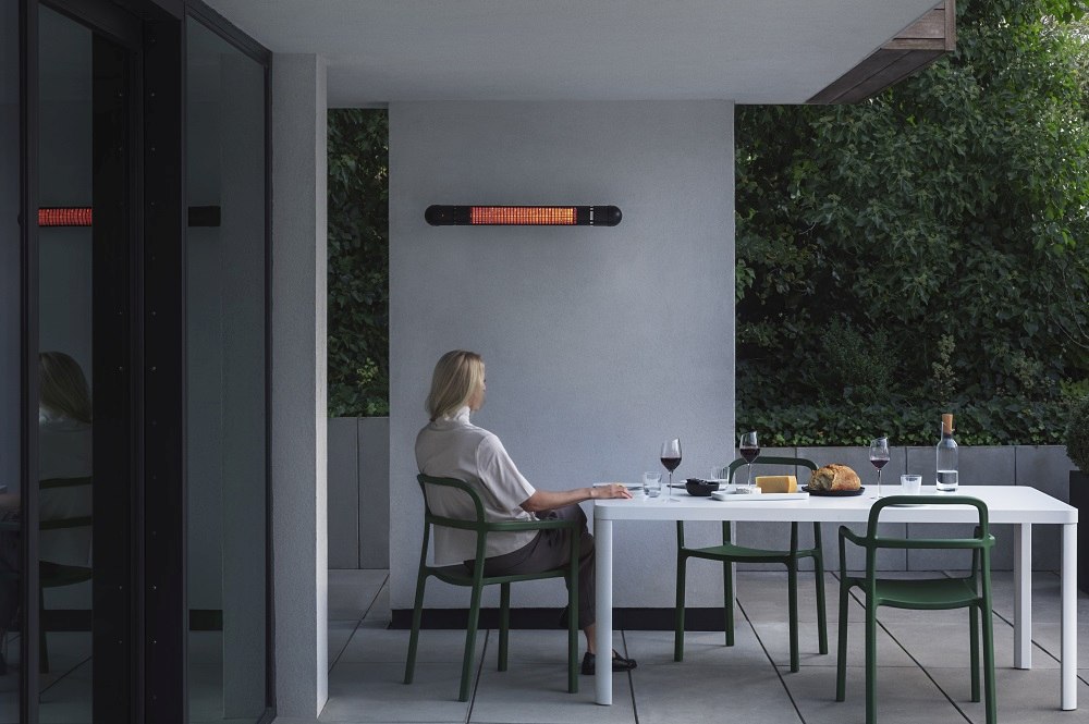 HeatUp Wall Terrassenheizer von Eva Solo über Esstisch auf einer modernen Terrasse.