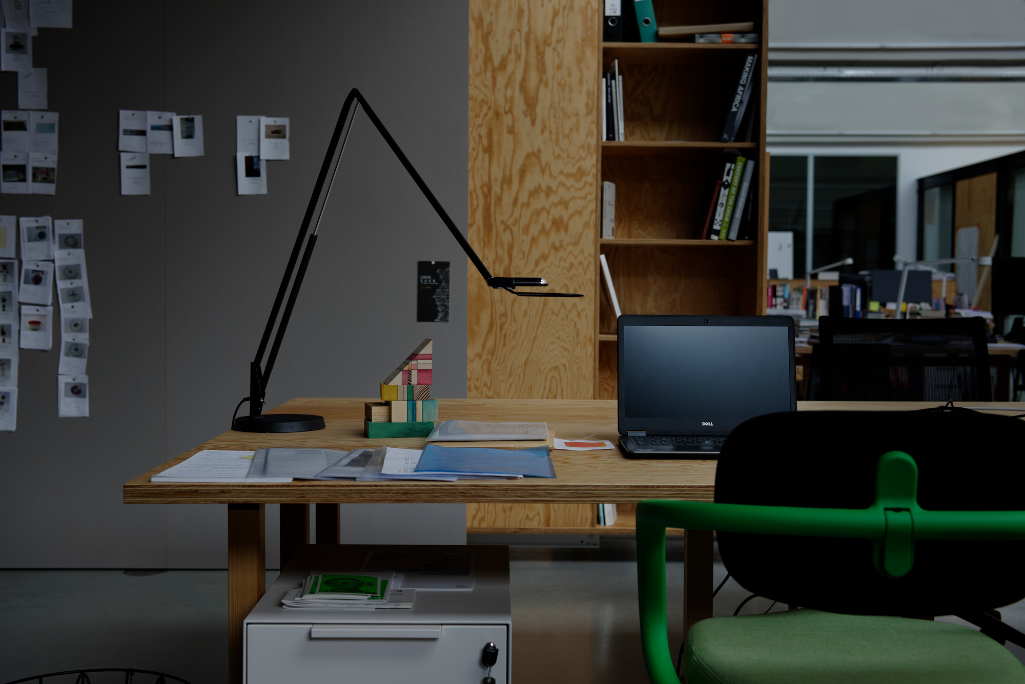 Liftolino LED Tischleuchte in Schwarz von Belux auf einem Schreibtisch im Büro.