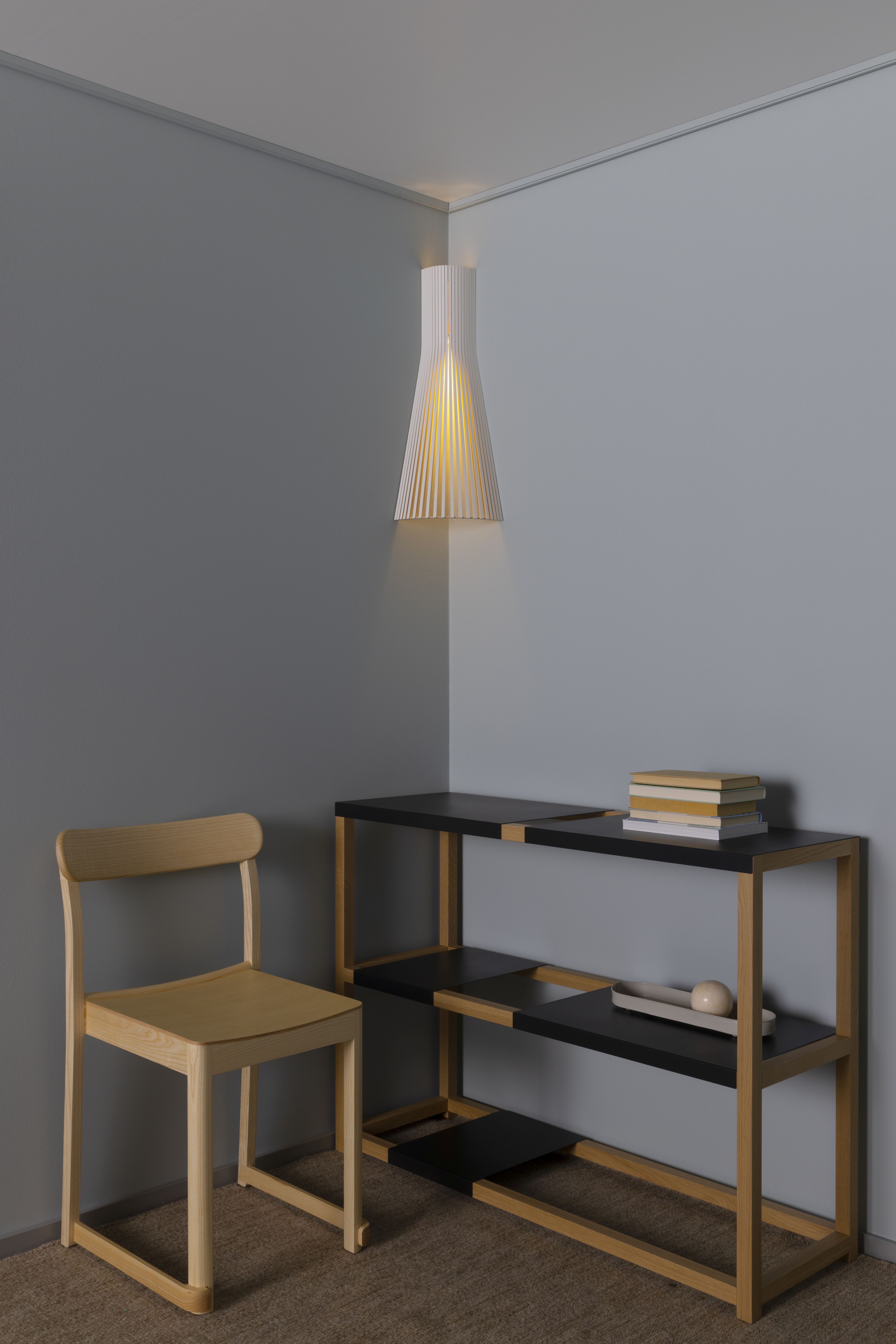 Secto 4236 Eckleuchte: Moderne skandinavische Designlampe aus Holzfurnier, indirekte Beleuchtung im Wohnraum mit Stuhl und Regal.