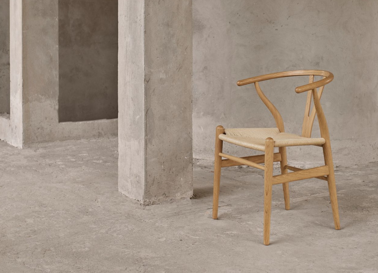 Heller Holzstuhl mit geflochtener Sitzfläche, Wishbone Chair Design, skandinavisches Möbeldesign für Esszimmer und Wohnbereich.