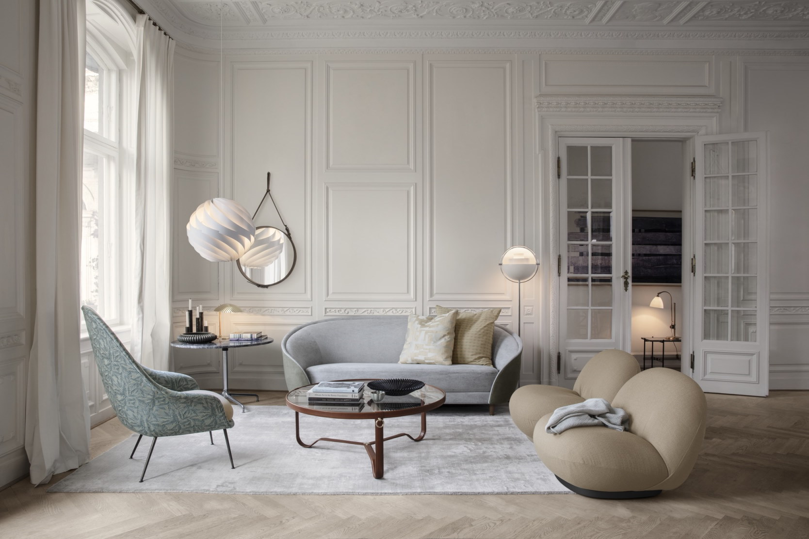 Wohnzimmer mit Gubi Adnet Coffee Table Couchtisch, Sofa, Sessel und moderner Beleuchtung.