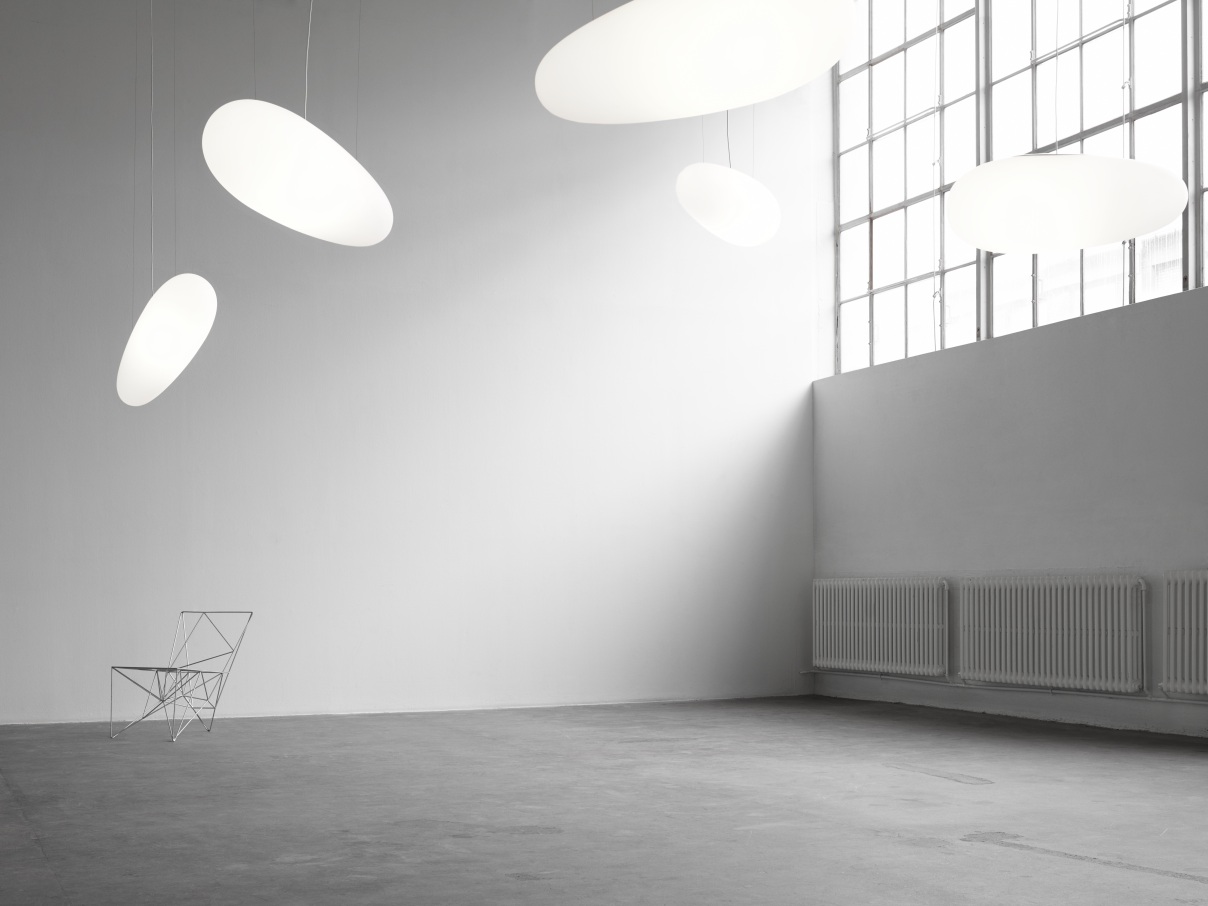 Helle, moderne Räumlichkeit mit mehreren weißen Avion Pendelleuchten von Fritz Hansen und einem Design-Stuhl.