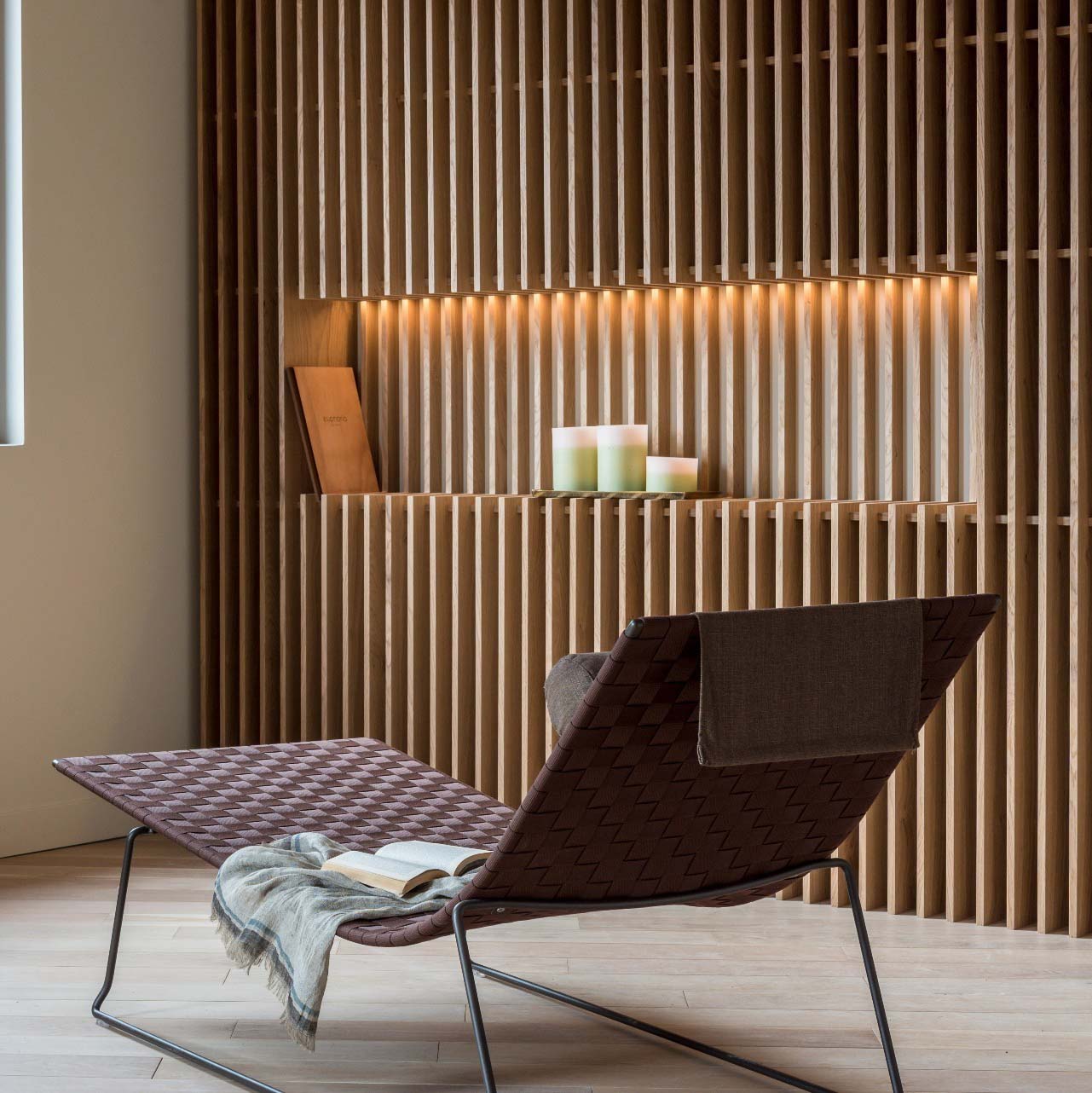Trenza Chaise Lounge TU0704 von Andreu World, braunes Outdoor Liege mit Buch und Decke.