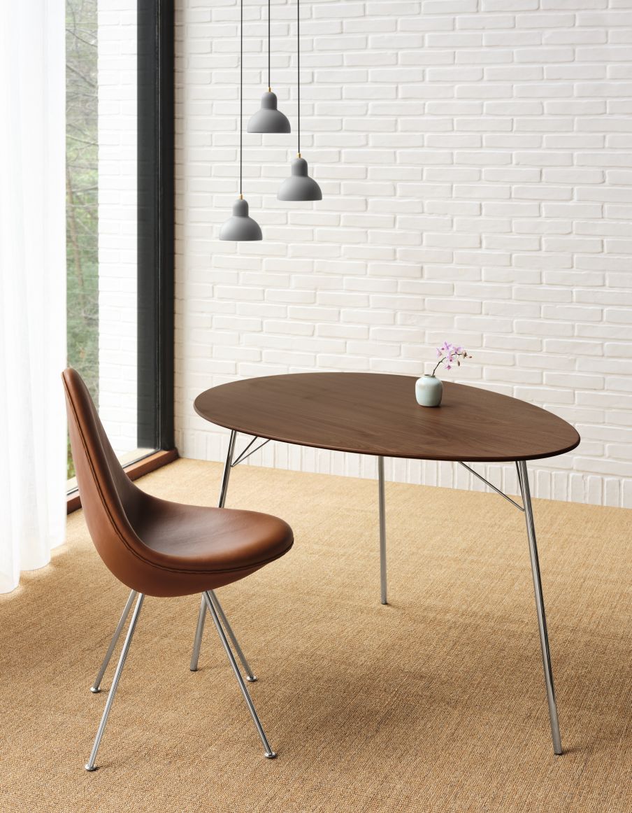 Fritz Hansen Egg Table Tisch mit brauner Tischplatte und silbernen Beinen, dazu ein brauner Ledersessel.