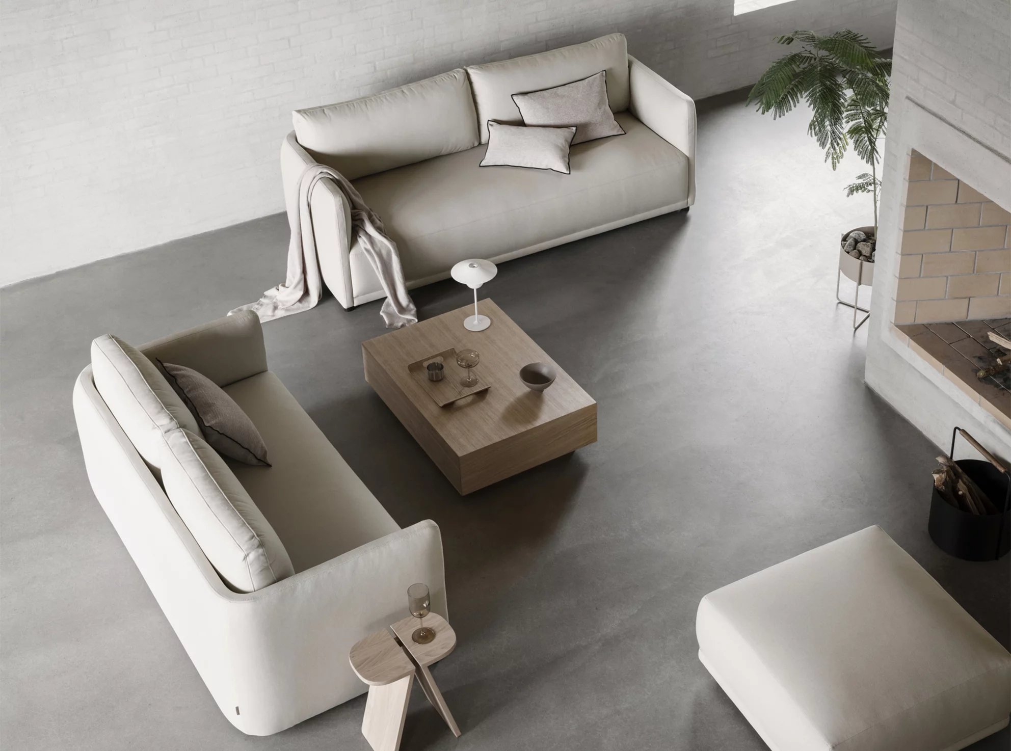 Helle Wohnzimmer-Szene mit Blomus Goba Coffee Table Couchtisch aus Holz, Sofas und Dekoration von oben.