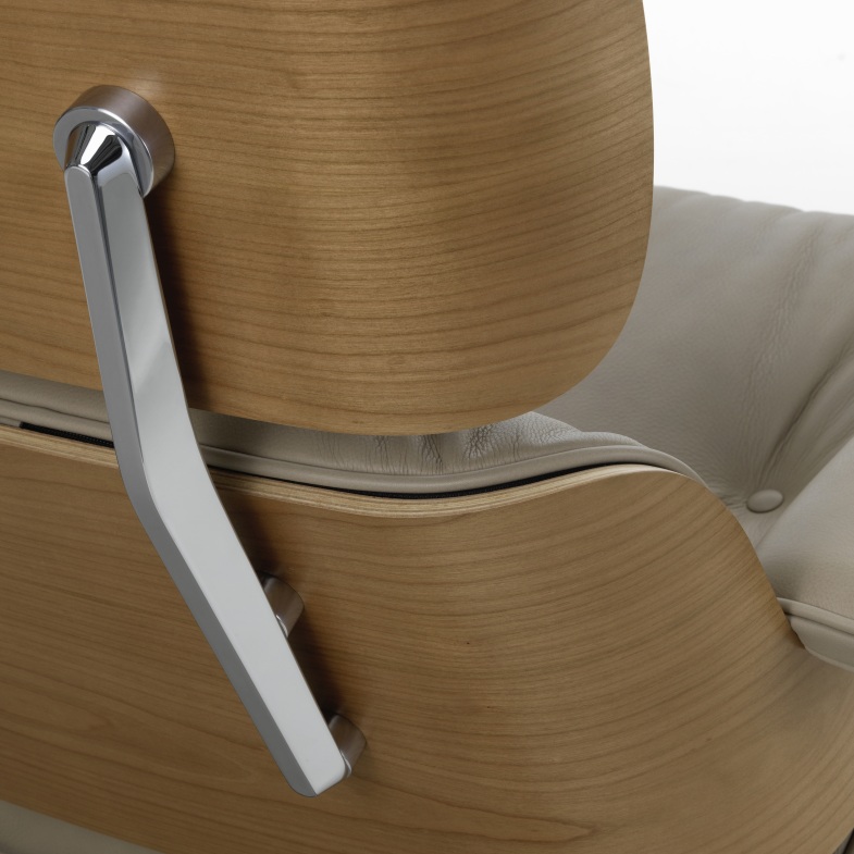 Detailaufnahme Eames Lounge Chair Sessel: Holzschale, helles Lederpolster und verchromtes Gestell, Designklassiker für Wohnzimmer.