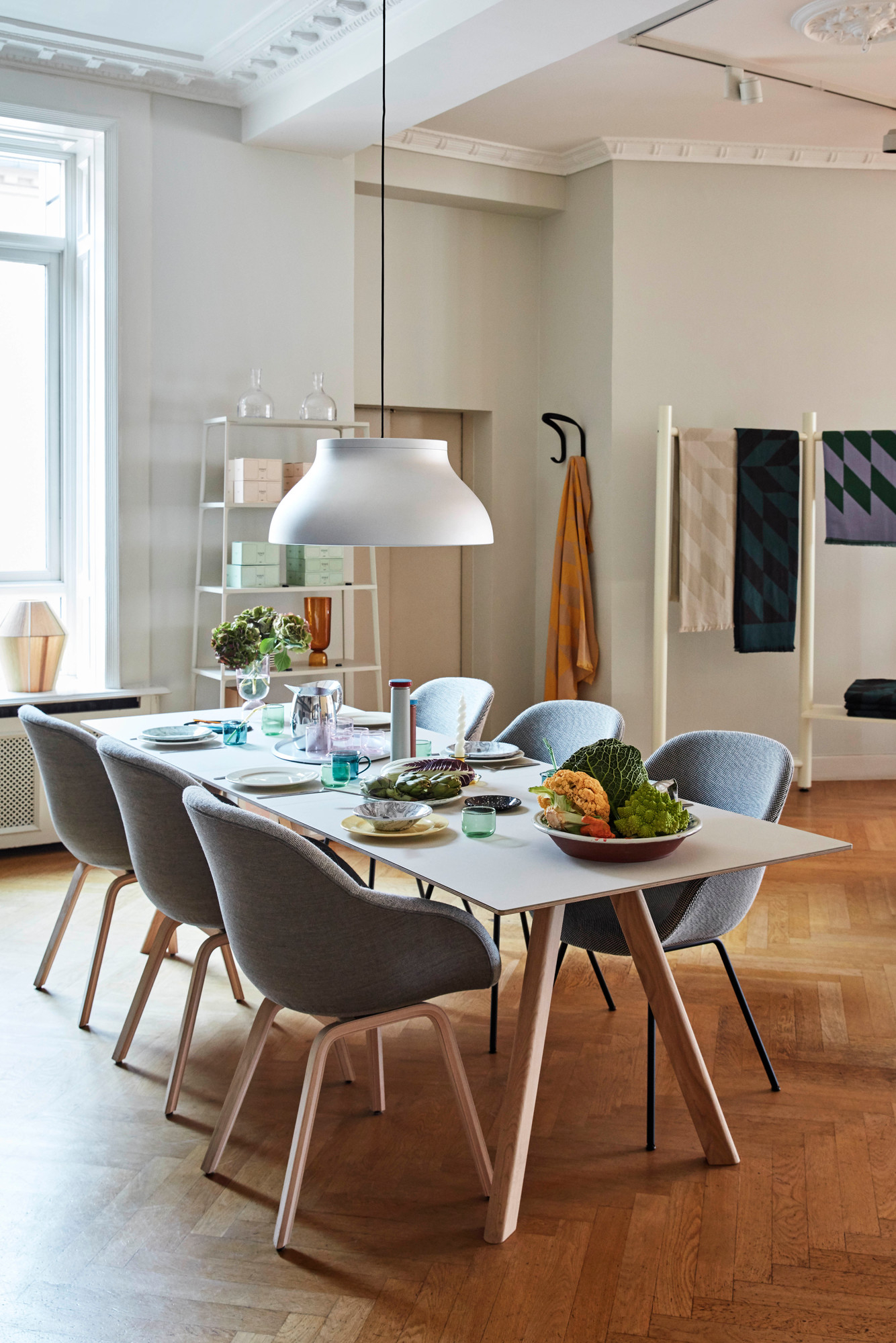 Esstisch mit sechs grauen Hay About a Chair AAC123 Stühlen mit Holzbeinen in einem hellen Esszimmer.