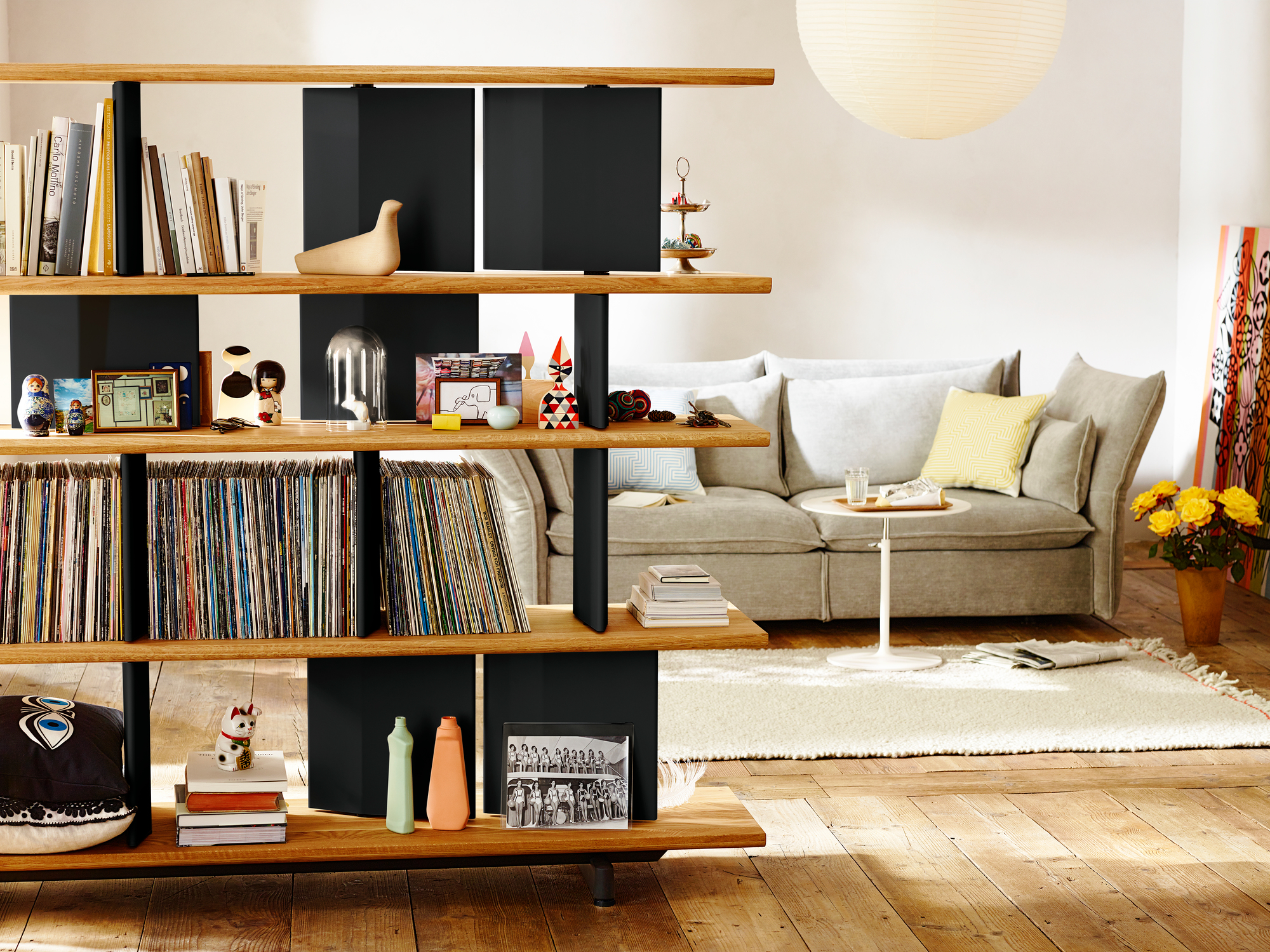 Wohnzimmer mit Vitra Mariposa Sofa, Bücherregal und Dekoration für gemütliches Wohnambiente.