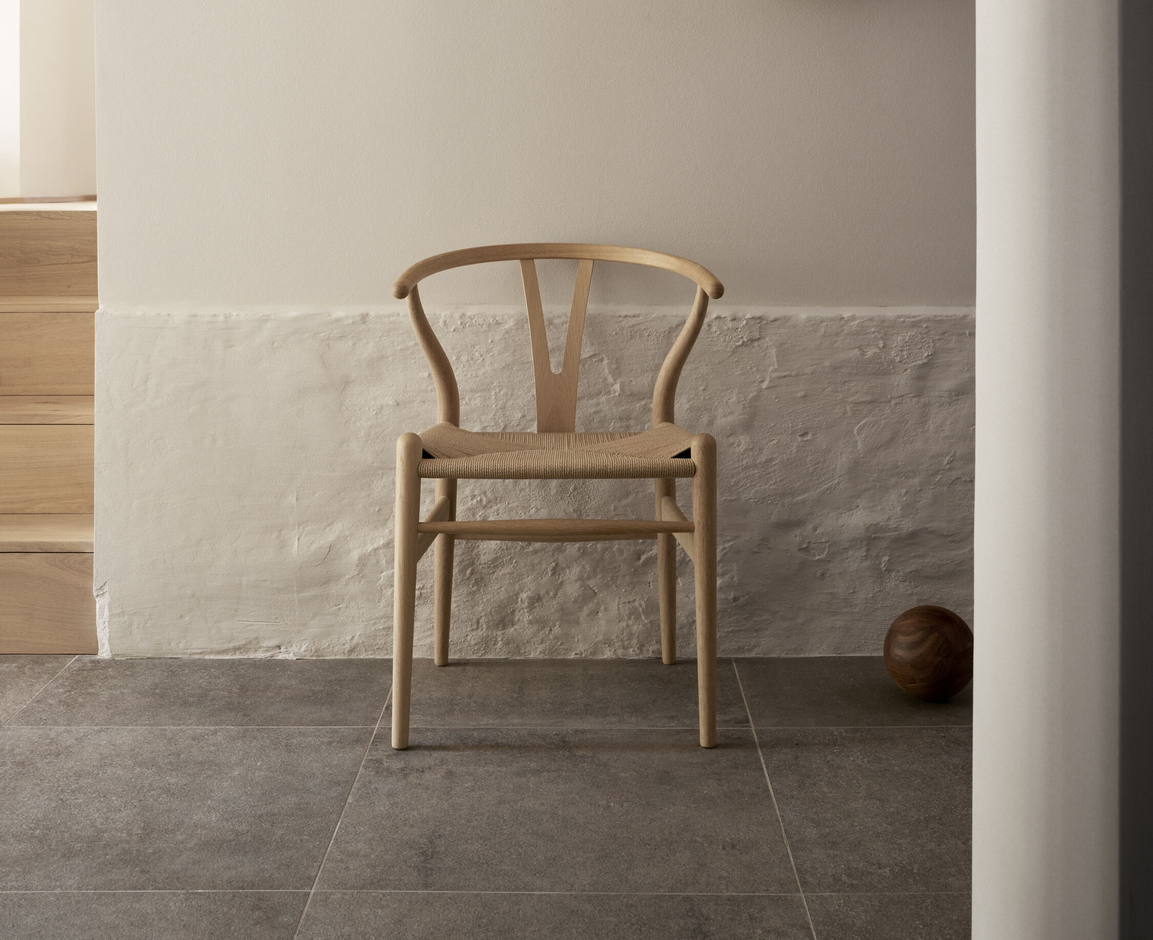Heller Holzstuhl mit geflochtener Sitzfläche, Wishbone Chair Design, skandinavisches Möbeldesign für Esszimmer und Wohnbereich.