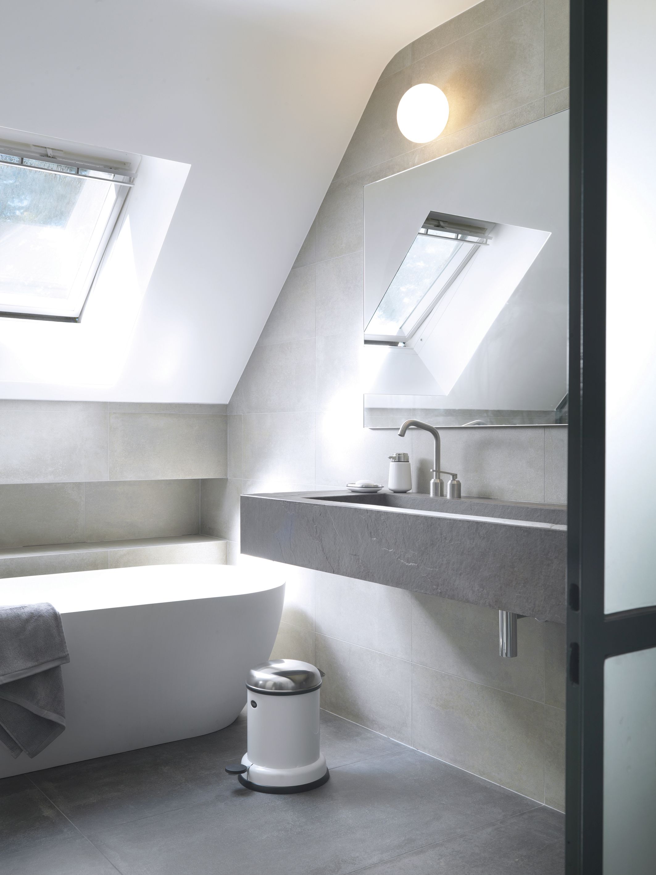 Weißer Vipp Treteimer im modernen Badezimmer mit Badewanne, Waschbecken und Dachfenster für stilvolle Badgestaltung.