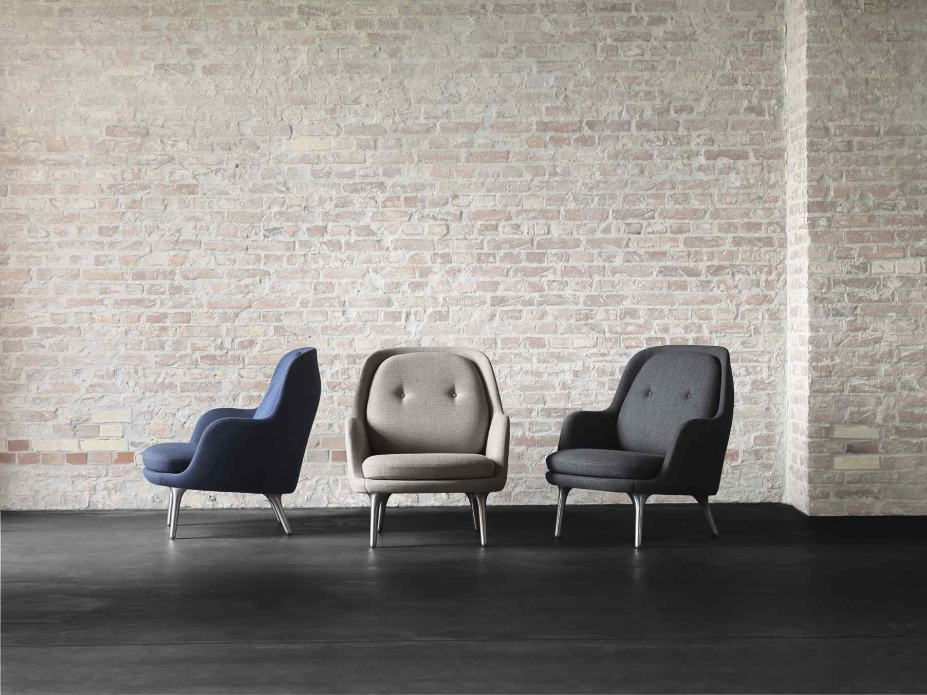 Drei Fri Sessel von Fritz Hansen in Blau, Grau und Anthrazit vor einer Backsteinwand.