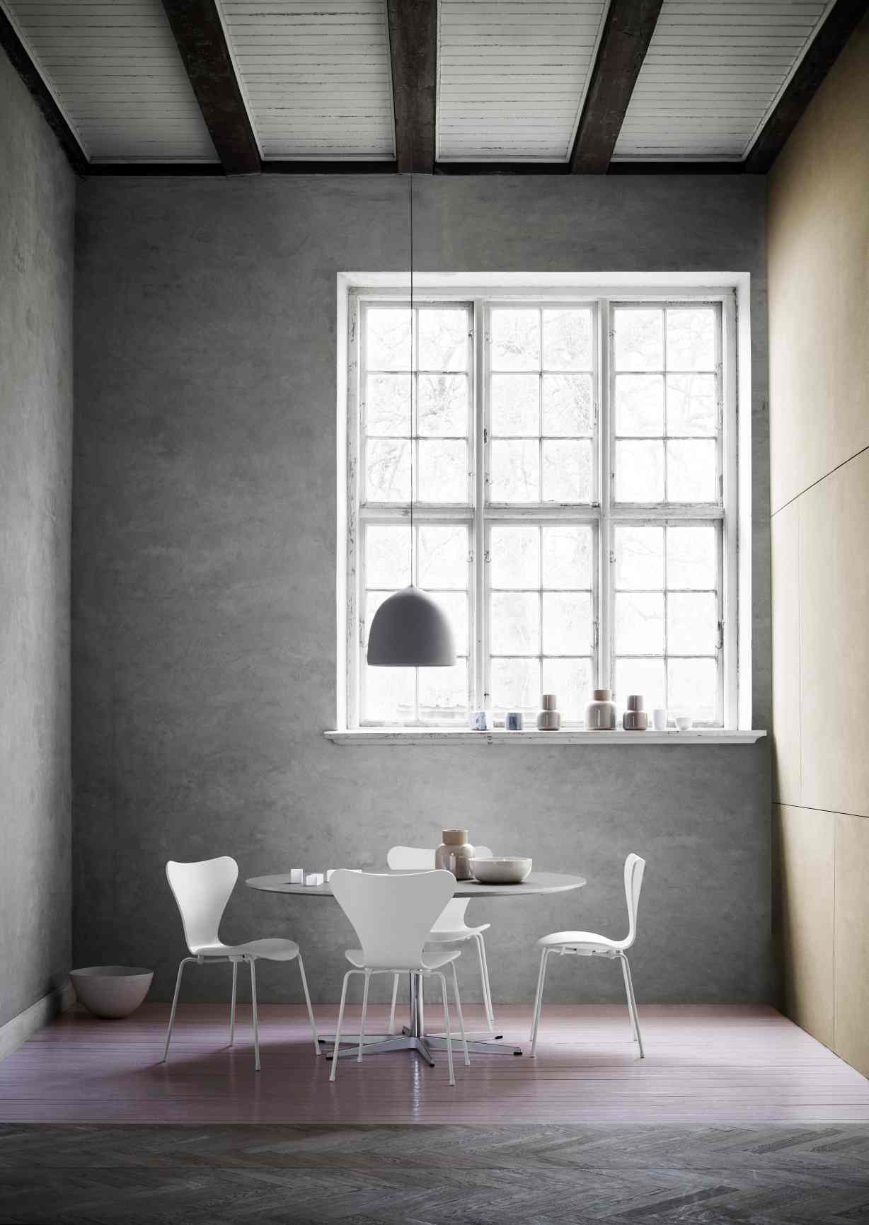 Vier weiße Siebener Stühle von Fritz Hansen um einen runden Tisch in einem modernem Esszimmer.