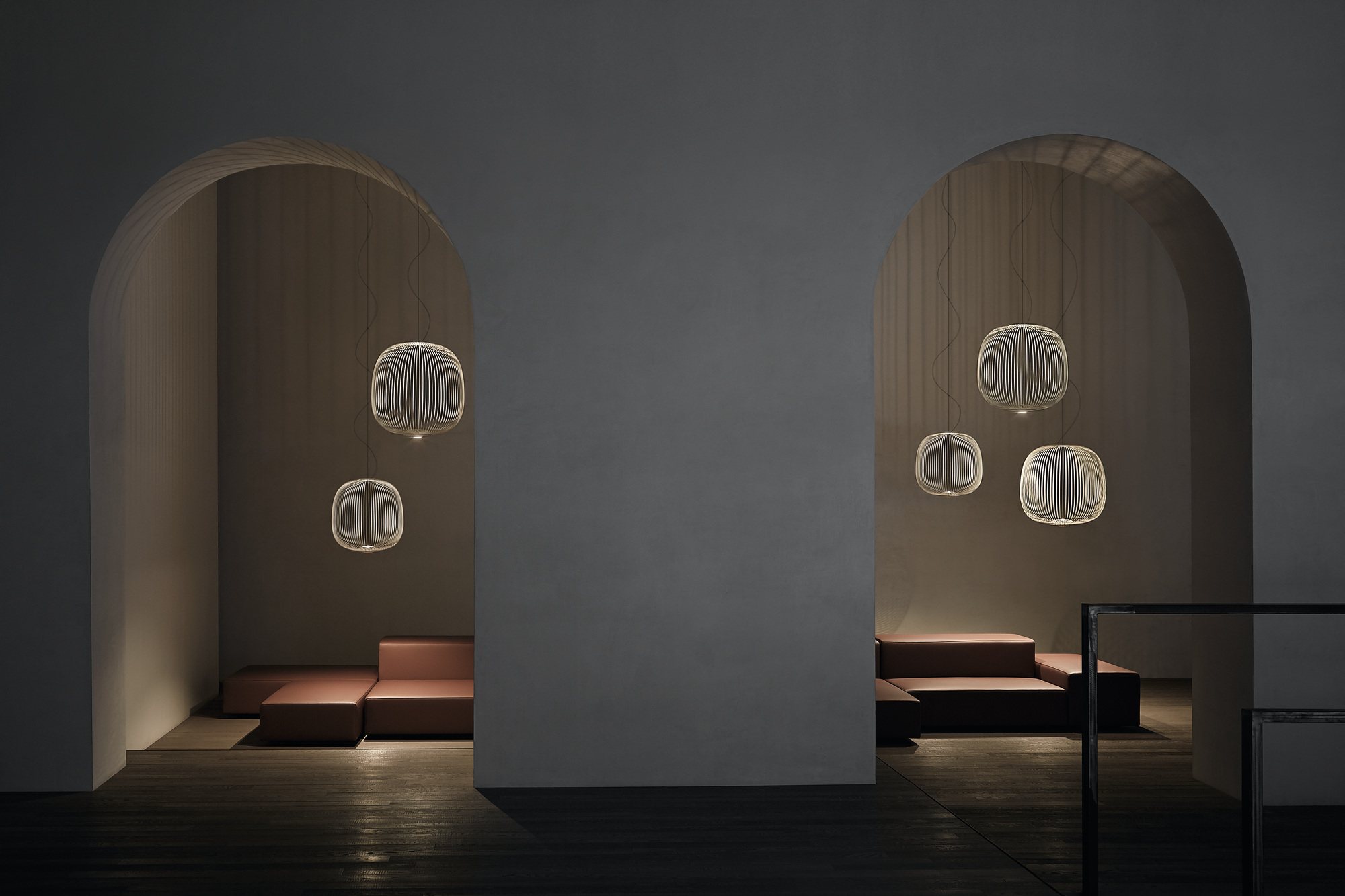 Innenaufnahme mit mehreren Spokes 2 LED Pendelleuchten von Foscarini über modernen, modularen Sofas.
