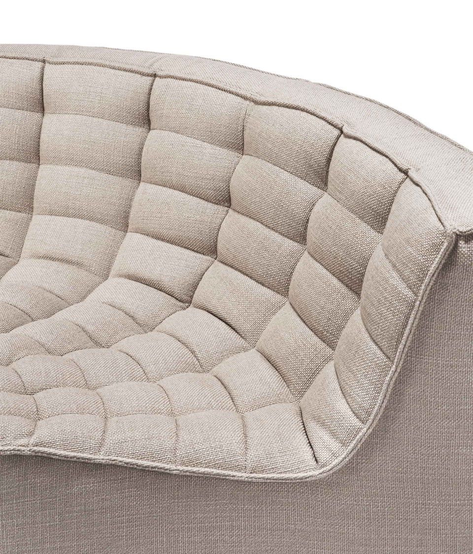 Detailaufnahme des N701 Sofas von Ethnicraft: Runde Ecke mit gesteppter, beiger Polsterung.