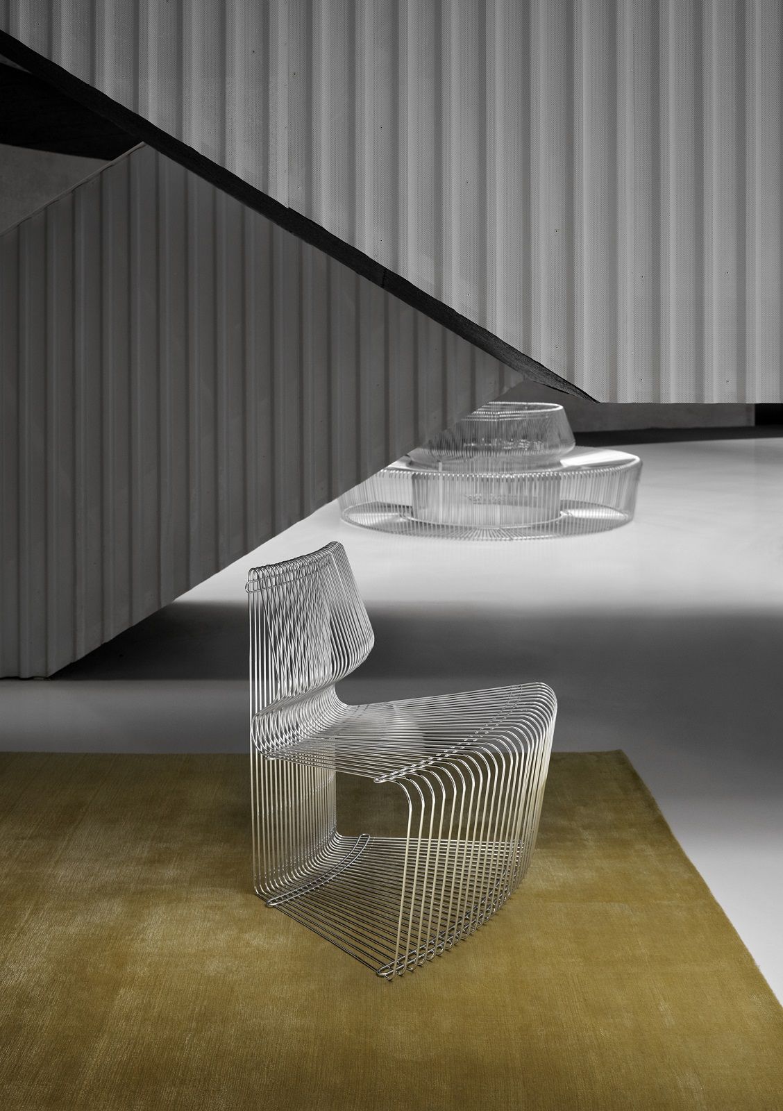 Pantonova System Sitzmodul Drahtstuhl von Montana, minimalistisches Designobjekt aus verchromtem Stahldraht auf Teppich.