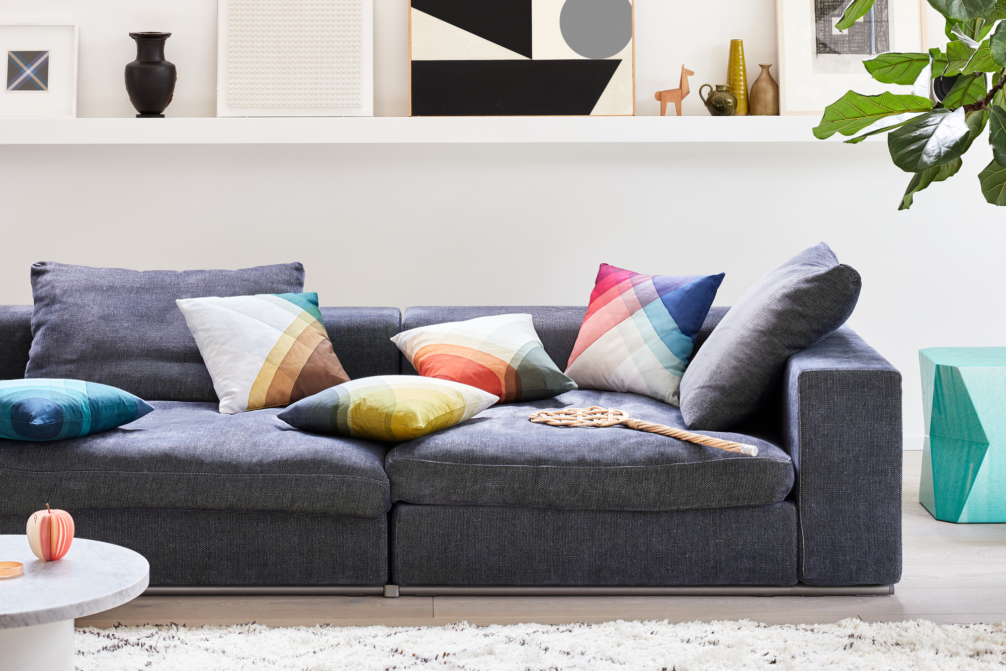 Graues Sofa mit bunten Heringbone Pillows Kissen von Vitra im Wohnzimmer mit Deko.