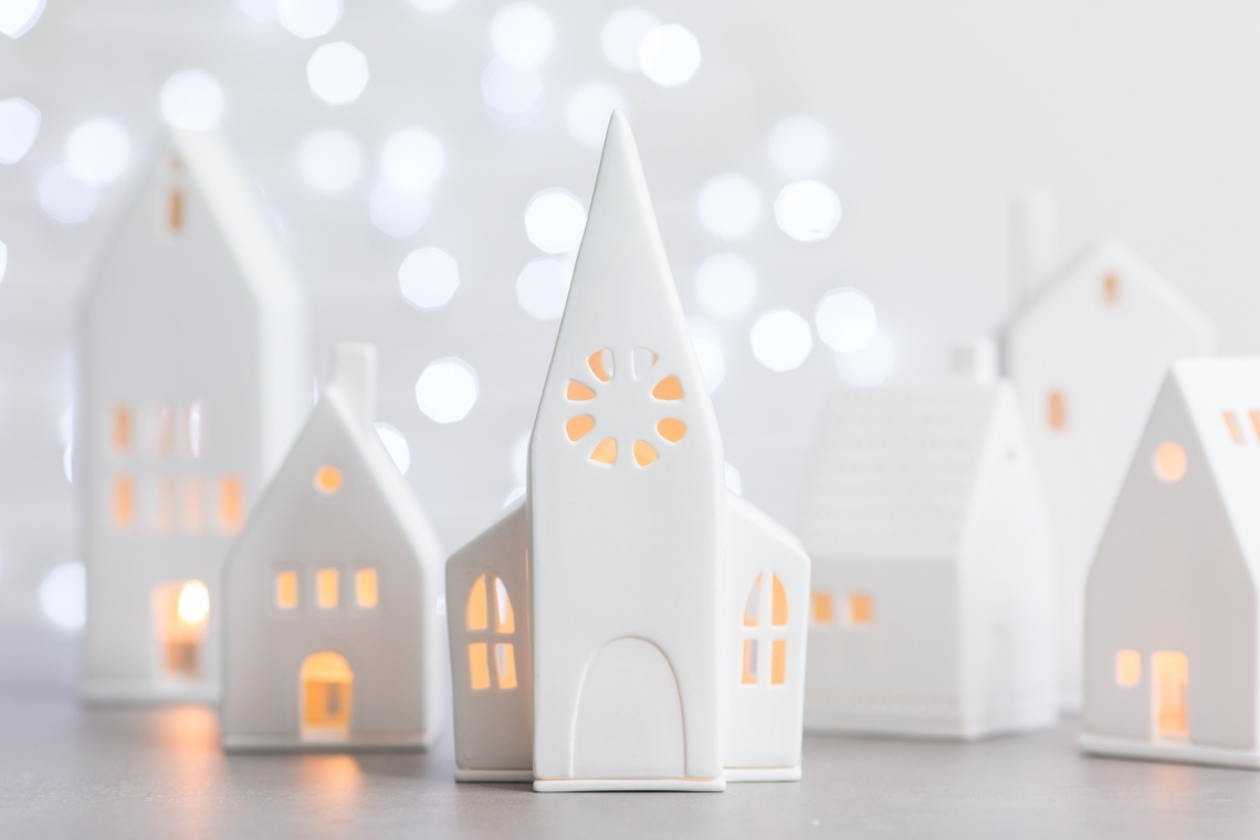 Detailaufnahme eines weißen Lichthaus Kirche Deko-Objekts, Teil einer weihnachtlichen Häuser-Kollektion mit warmem Kerzenlicht.