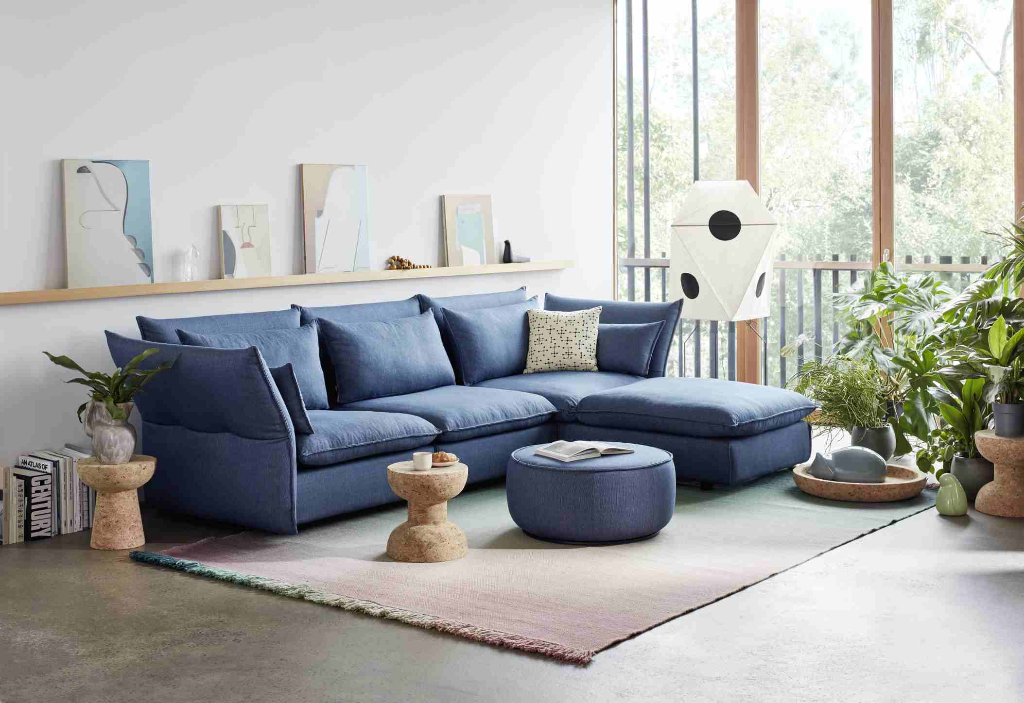 Blaues Mariposa Sofa Eckmodul von Vitra mit Kissen und Ottomane in modernem Wohnzimmer.