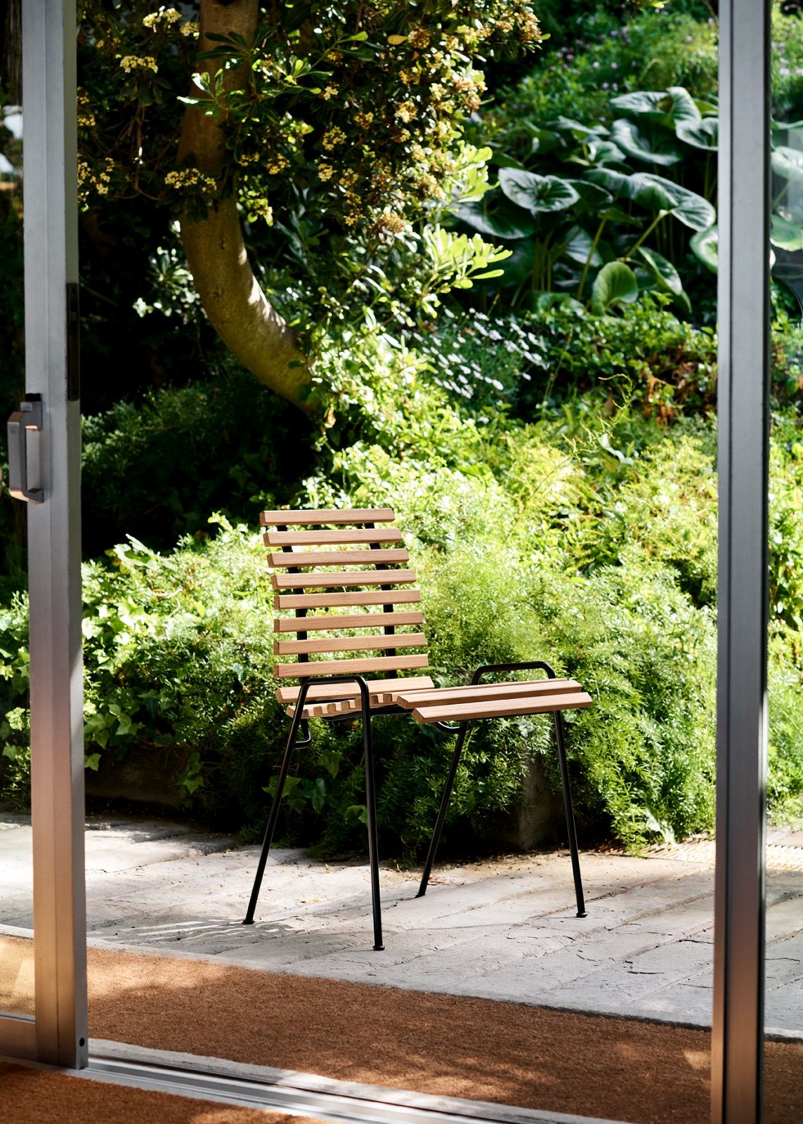 RFH Robin Day RD4 Esszimmerstuhl von AndTradition aus Holz und Metall im Garten.