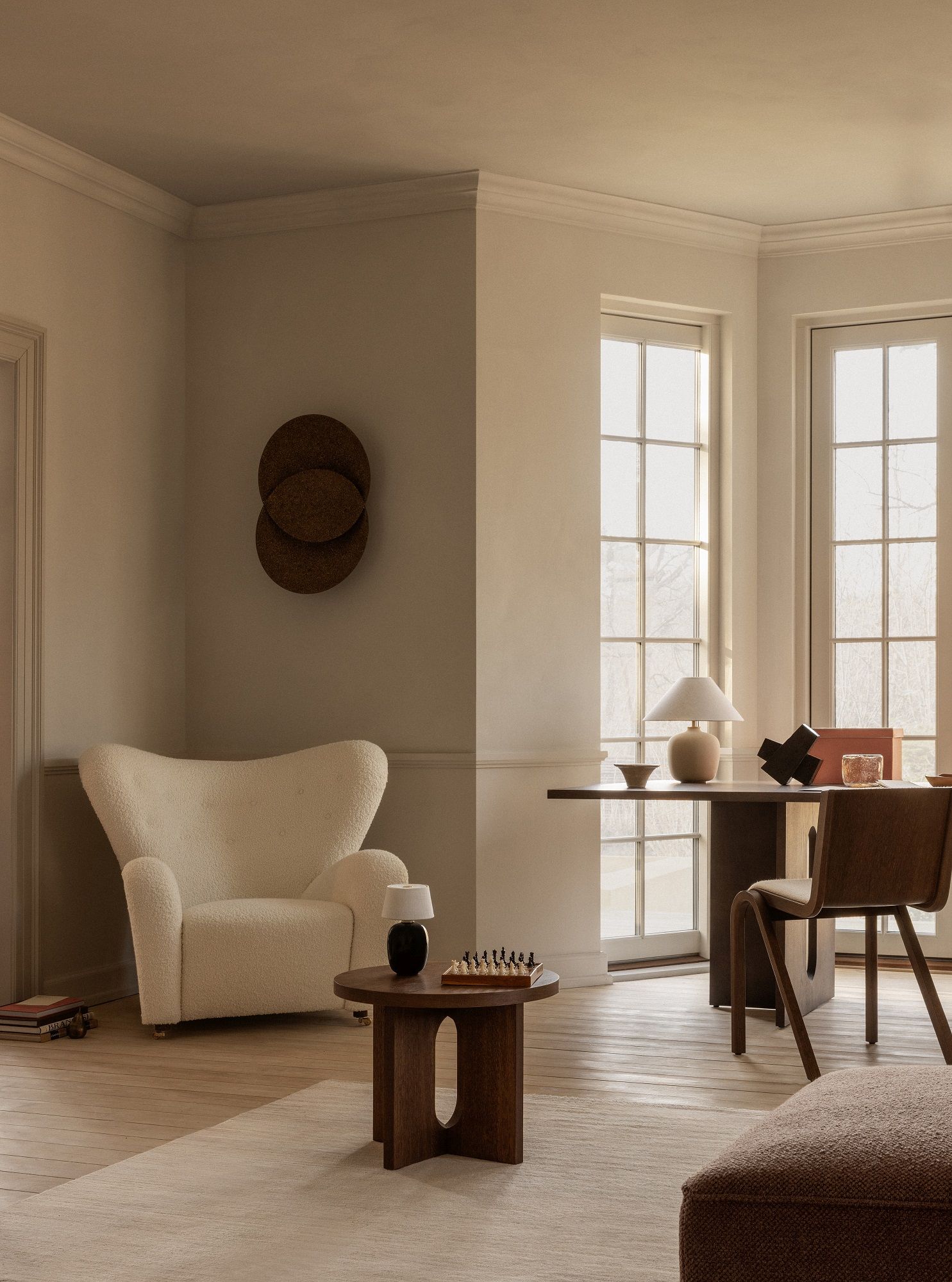 Heller Wohnraum mit Audo Copenhagen Ready Dining Chair, vollgepolsterter Stuhl aus Holz und beigem Stoff.