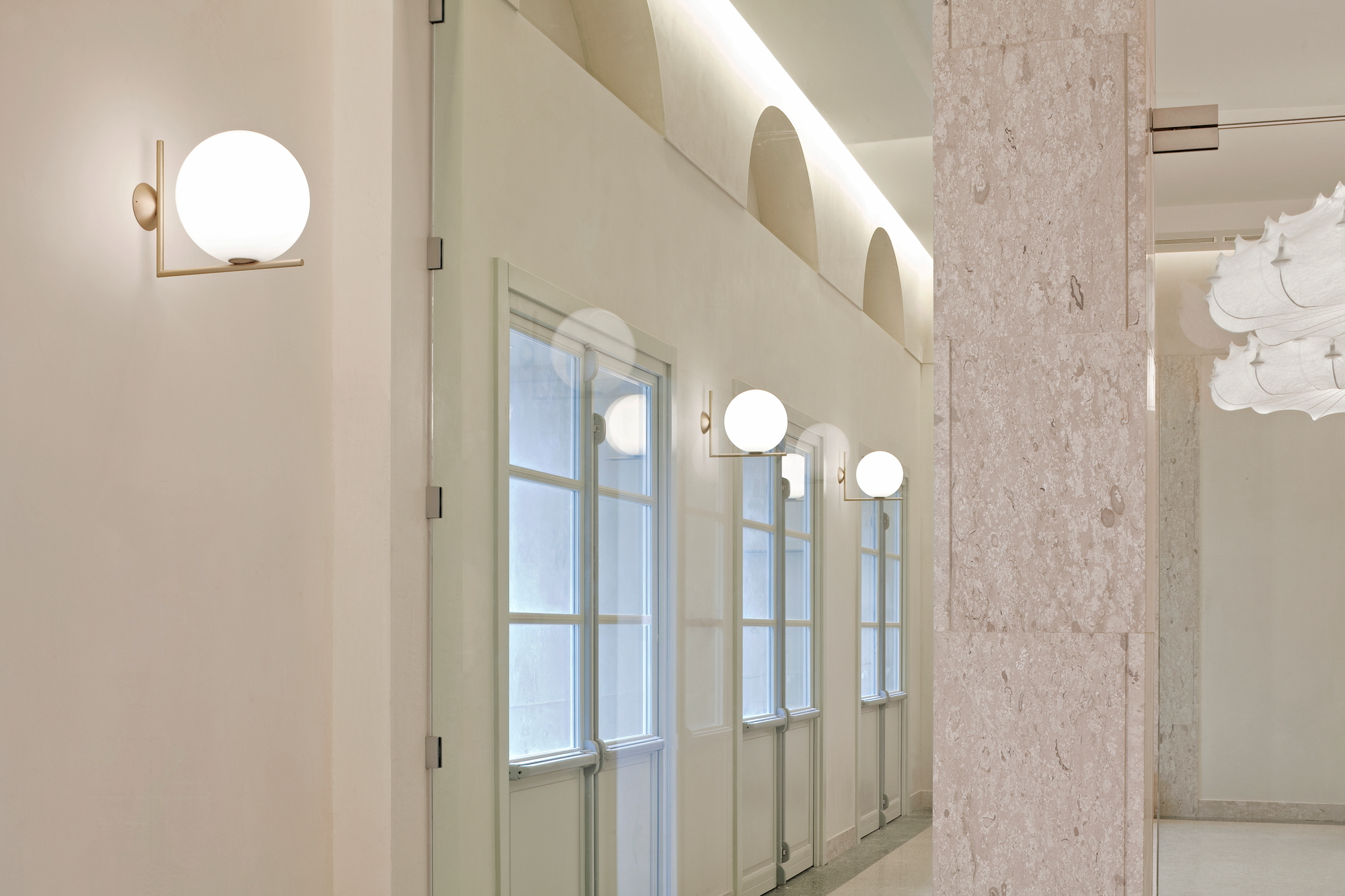 IC Lights Wandleuchte von Flos: Moderne Innenleuchte mit Kugel und goldenem Arm.