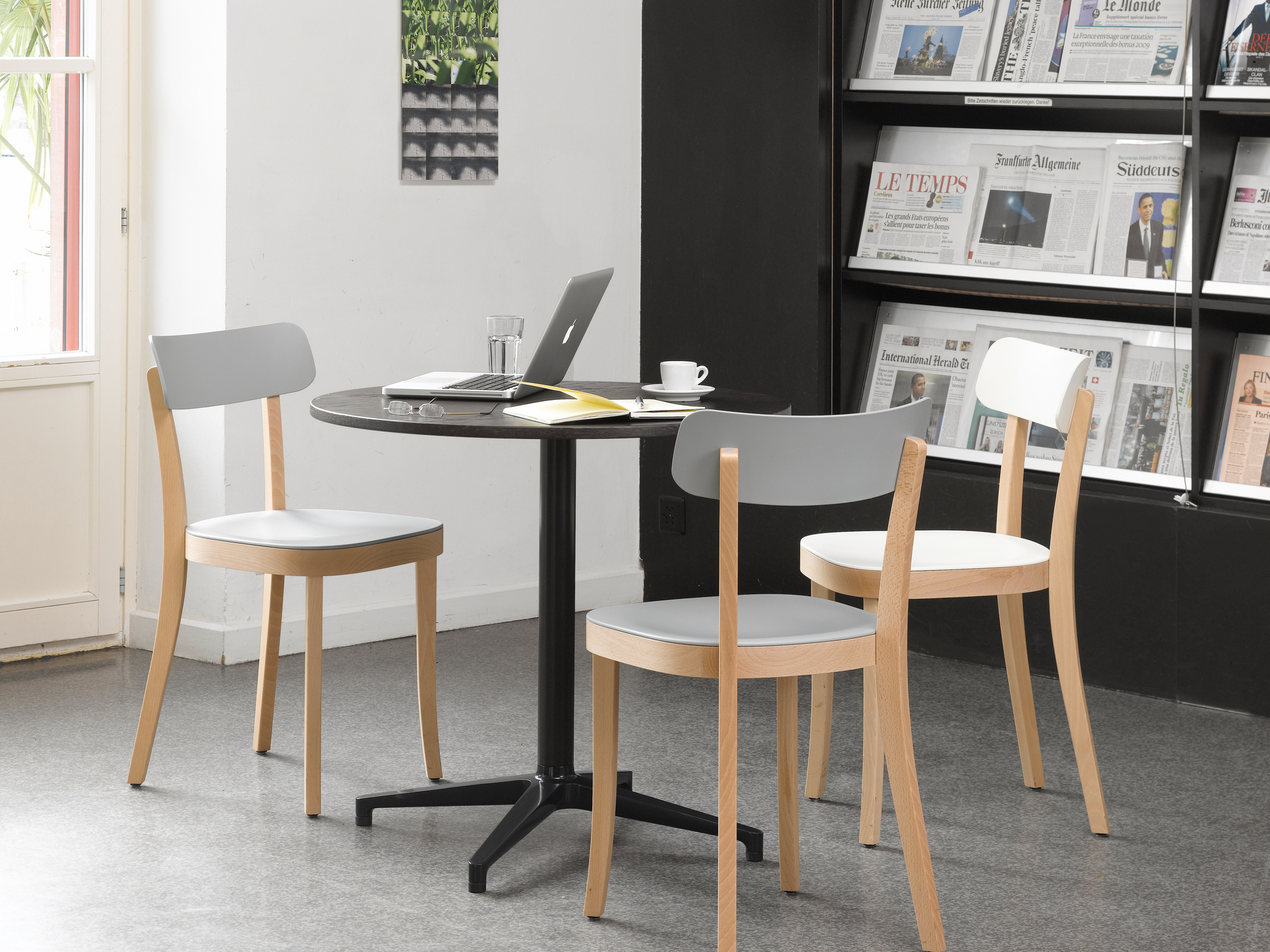 Vitra Bistro Table mit runder Tischplatte und Stühlen in einem modernen Café oder Büro.