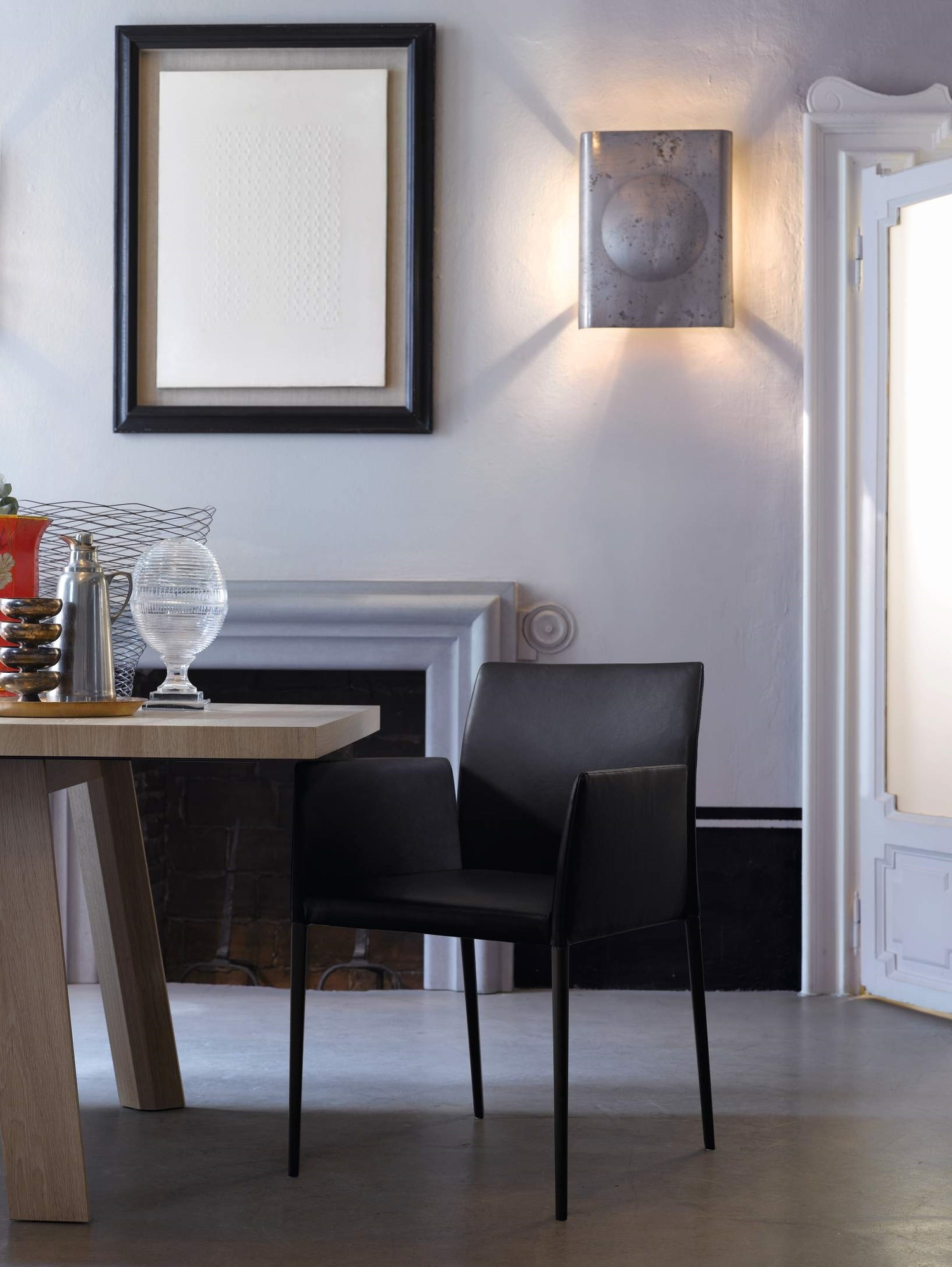 Nahaufnahme des Tadeo Table Tisch von Walter Knoll mit schwarzem Lederstuhl in modernem Esszimmer.