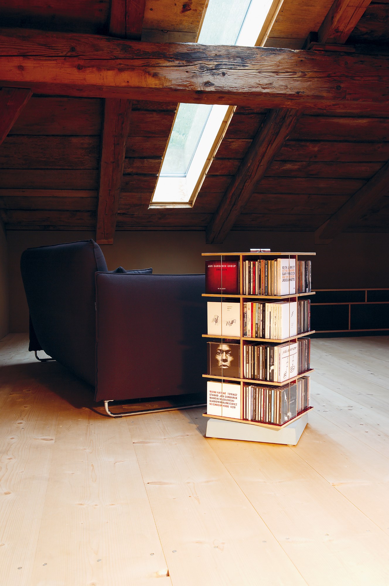 Musikstapler CD-Regal von Nils Holger Moormann im Dachgeschoss mit Dachfenster und Sofa.