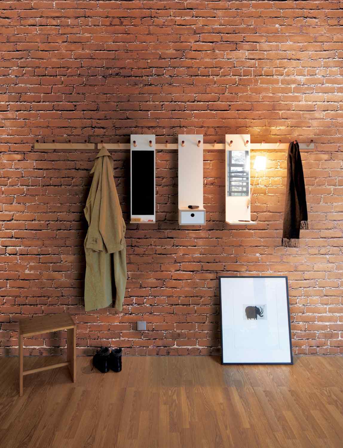 Moderne Garderobe mit Spiegel, Hakenleiste und Ablage vor einer Backsteinwand. Jacke, Schal, Schuhe und Bild.