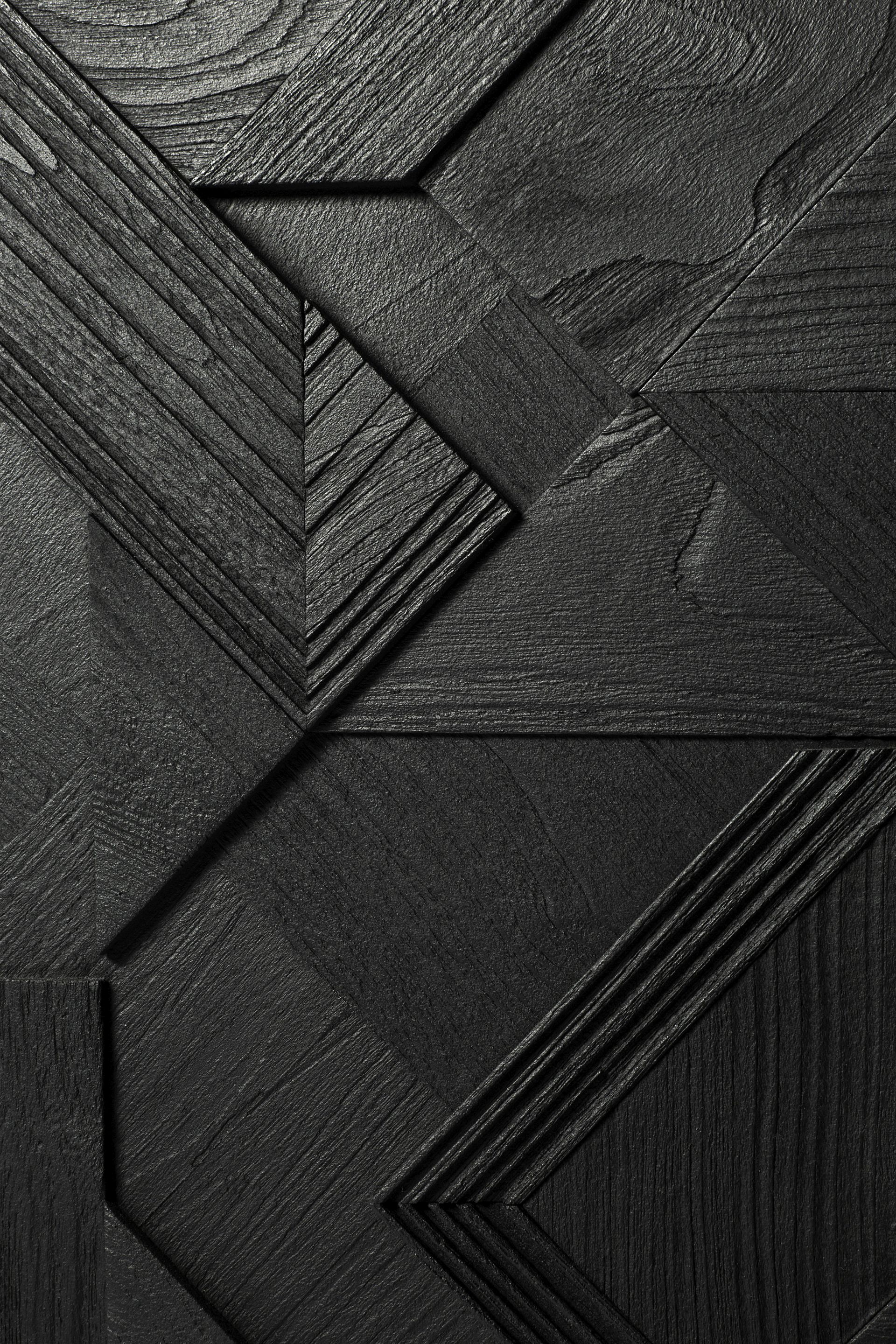Detailaufnahme der schwarzen Graphic Teak Anrichte von Ethnicraft mit geometrischen Mustern und Holzstruktur.