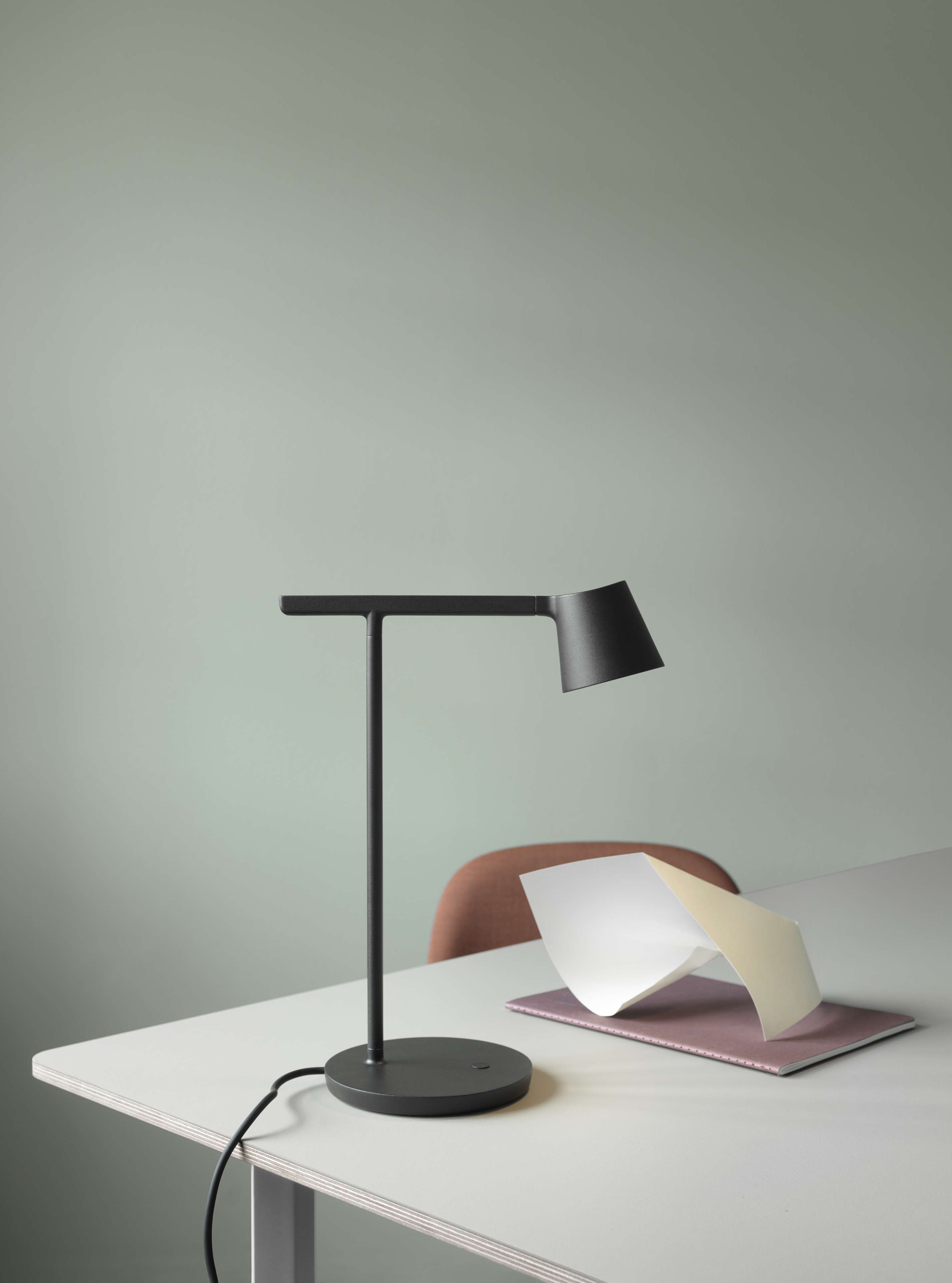 Schwarze Tip Table Lamp Tischleuchte von Muuto auf einem Schreibtisch mit Notizbuch und Papieren.