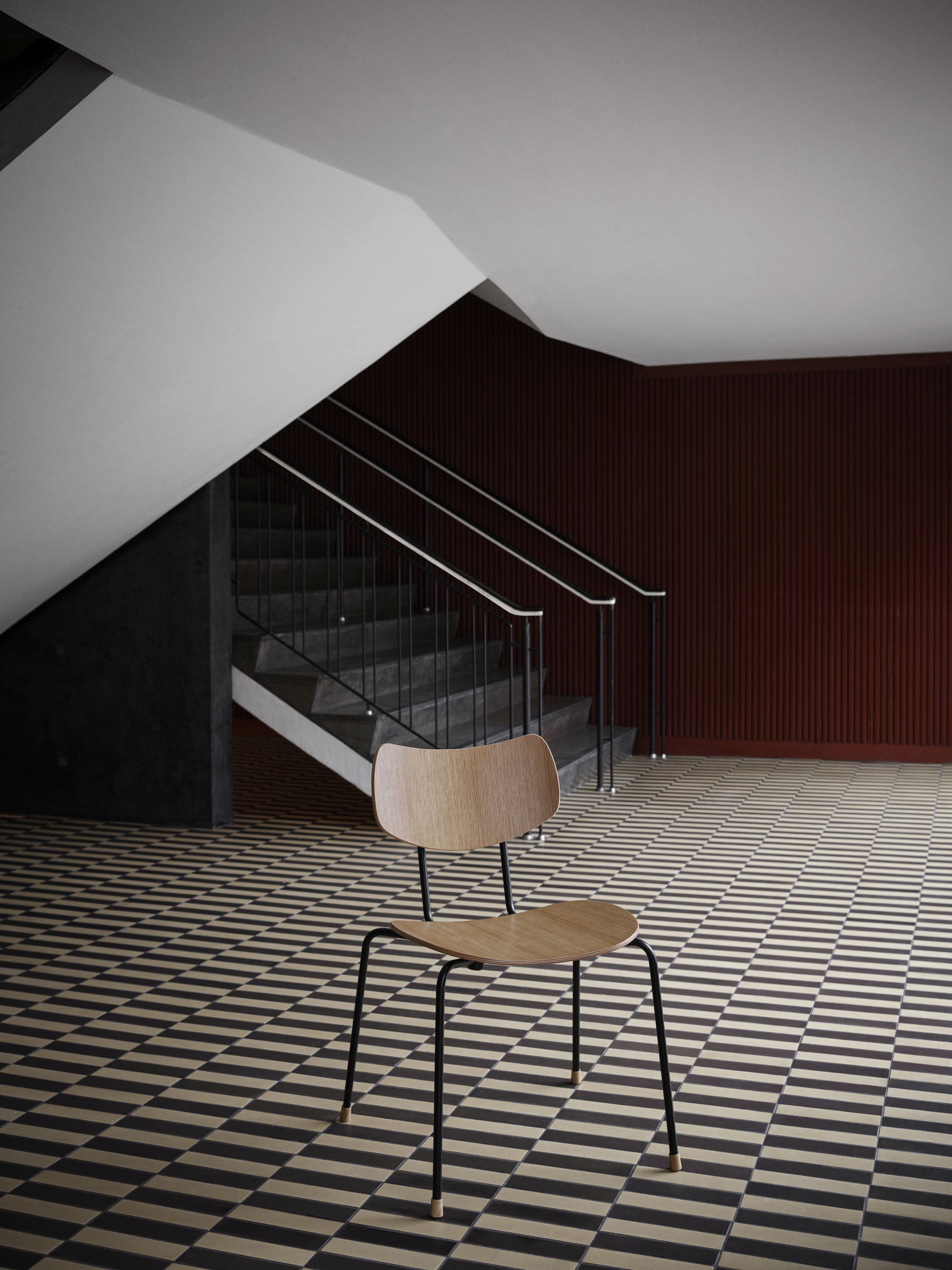 Vega Chair von Carl Hansen & Søn, Holzstuhl mit schwarzem Metallgestell vor Treppenhaus.