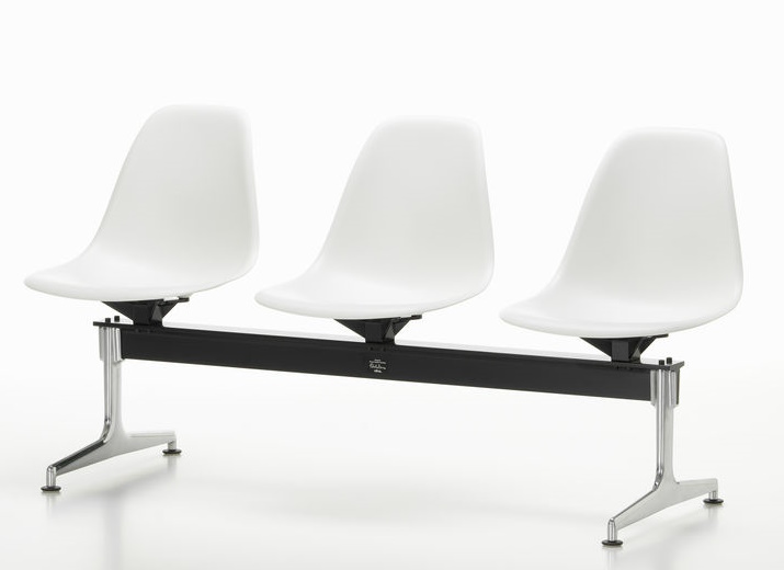 Eames Plastic Side Chair RE auf Traverse von Vitra, Wartebereich mit drei weißen Kunststoffschalen.