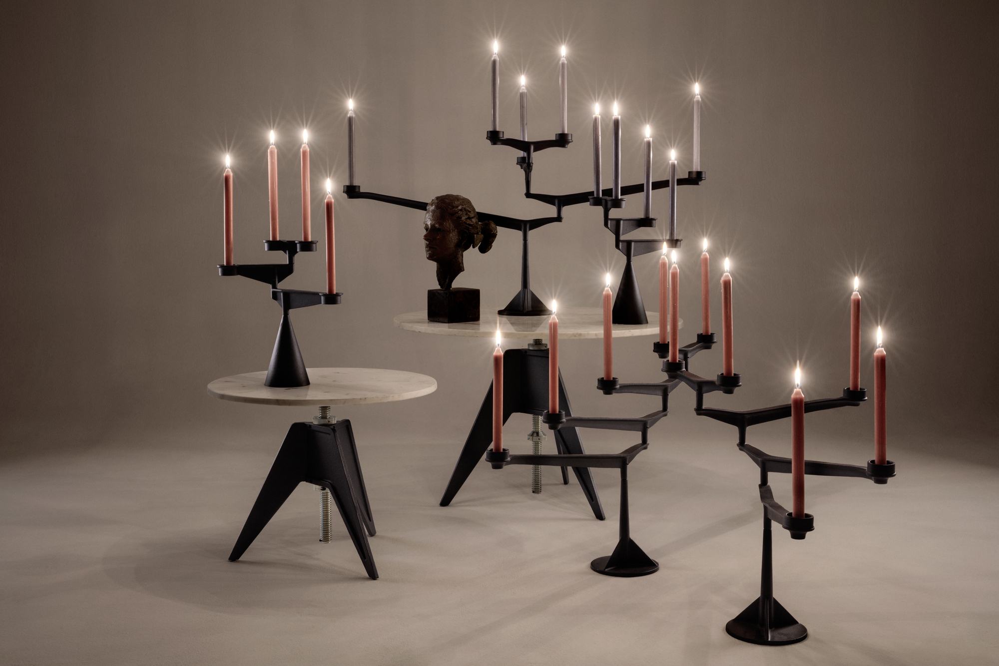 Mehrere Spin Candelabra Mini Kerzenständer von Tom Dixon, aus schwarzem Metall mit brennenden Kerzen.