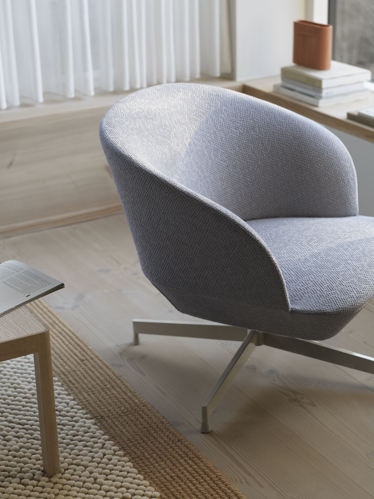 Nahaufnahme des grauen Oslo Lounge Sessels von Muuto mit Drehfuß.